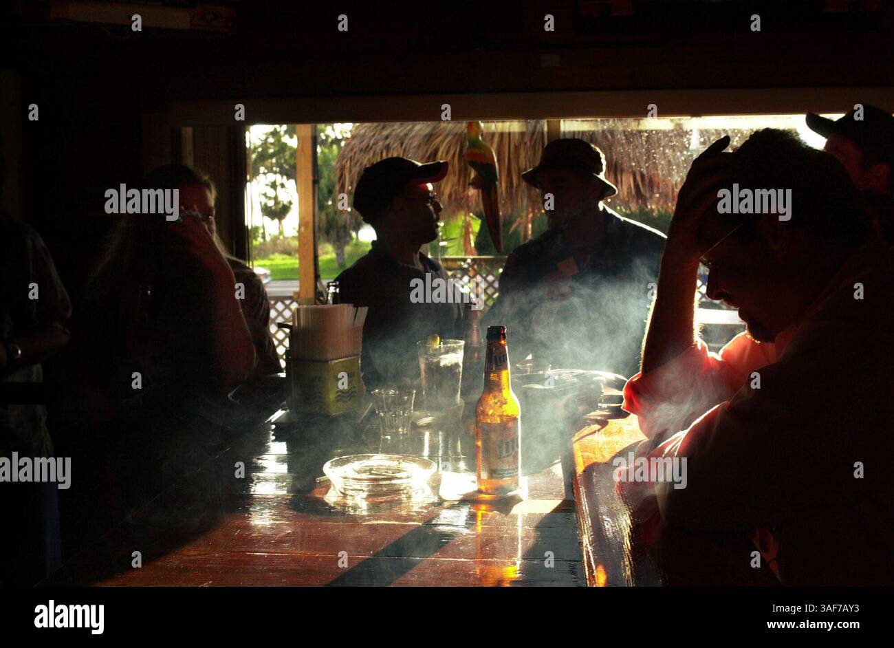 NP 143428 - - CONSEGNA A: FLORIDIAN - - 7/12/2002 - - DUNEDIN DIDASCALIA INFO: I clienti si godono sigarette, birra e liquori all'Eddie's Bar and Grill mentre il sole tramonta su Bayshore Boulevard a Dunedin viziano i loro vizi dopo una lunga settimana di lavoro in una bella giornata estiva con buoni amici.- - Times foto di: Douglas R. Clifford - - storia di: FLORIDIAN PROJECT - - - SCANSIONATO DA: drc - DATA di ESECUZIONE: 7/13/2002. (Immagine di credito: St Petersburg Times/ZUMAPRESS.com) Foto Stock