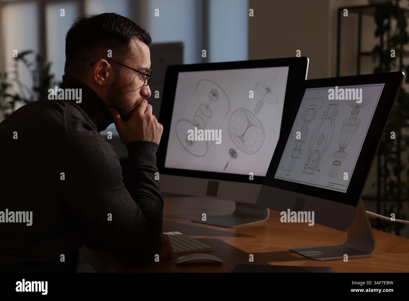 Ingegnere che lavora con disegni digitali al tavolo in ufficio Foto Stock