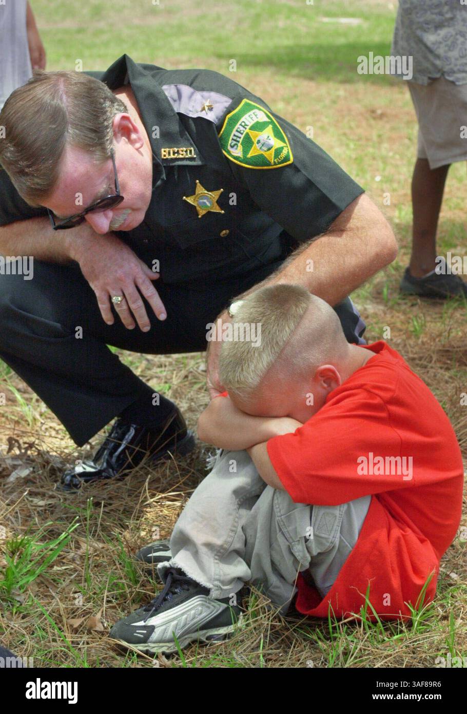 HT 124173 - - CONSEGNA A: HERNANDO - - 6/19/2001 - - BROOKSVILLE - - DIDASCALIA INFO: 2/2 Hernando County Sheriff Richard Nugent (CQ), sinistra, comfort camper Harley Poska (ortografia dal consulente), di Spring Hill, dopo che gli è stato detto di andare in fondo a una linea martedì prima dell'inizio delle attività durante i Florida Sheriffs Youth Ranches Harmony in the Streets mobile camp at Powell Middle School West of St Petersburg Times/ZUMAPRESS.com) Foto Stock