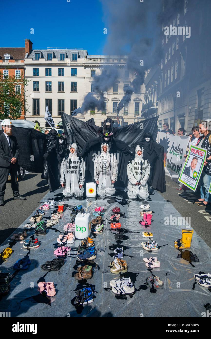 Londra, Regno Unito. 7 aprile 2025. Un manifestante vestito da dirigente della BP, e supportato da petroliere in vesti nere, versava olio su ribelli inginocchiati, e poi su file di scarpe vuote per bambini davanti all'edificio, simboleggiando ciò che la strategia della BP a U significa per il futuro dei nostri figli. Gli attivisti di età compresa tra i 4 e i 83 anni hanno occupato la strada fuori dal quartier generale di Londra di St James's Square della BP per chiedere al gigante petrolifero di invertire la loro decisione di rottamare la precedente strategia di transizione energetica sostenuta dagli azionisti. Il volto del CEO, Auchincloss, è apparso sui cartelli che recitano: "RICERCATO per distruggere i nostri Futures". Credito Bell/Alamy Foto Stock