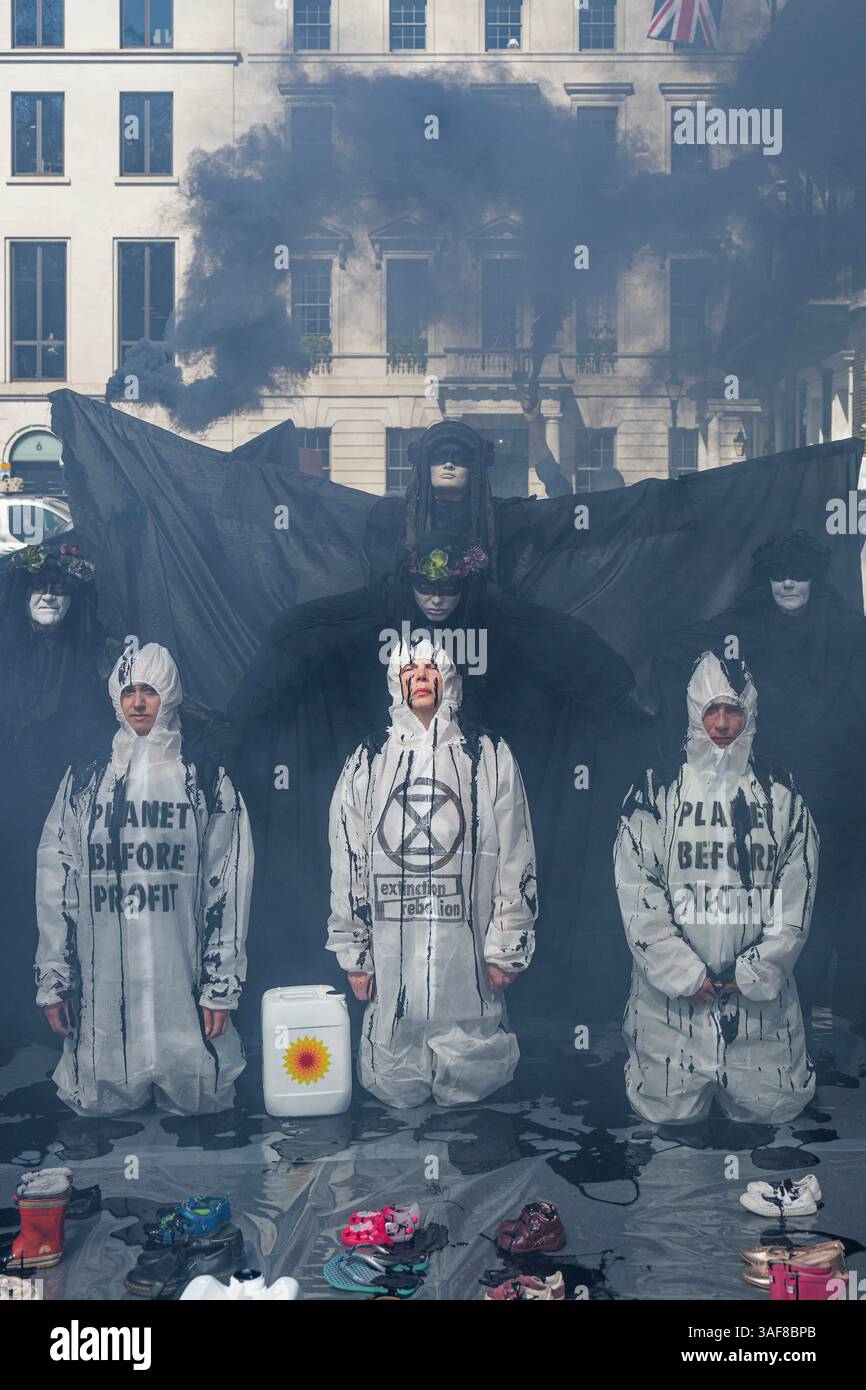 Londra, Regno Unito. 7 aprile 2025. Un manifestante vestito da dirigente della BP, e supportato da petroliere in vesti nere, versava olio su ribelli inginocchiati, e poi su file di scarpe vuote per bambini davanti all'edificio, simboleggiando ciò che la strategia della BP a U significa per il futuro dei nostri figli. Gli attivisti di età compresa tra i 4 e i 83 anni hanno occupato la strada fuori dal quartier generale di Londra di St James's Square della BP per chiedere al gigante petrolifero di invertire la loro decisione di rottamare la precedente strategia di transizione energetica sostenuta dagli azionisti. Il volto del CEO, Auchincloss, è apparso sui cartelli che recitano: "RICERCATO per distruggere i nostri Futures". Credito Bell/Alamy Foto Stock