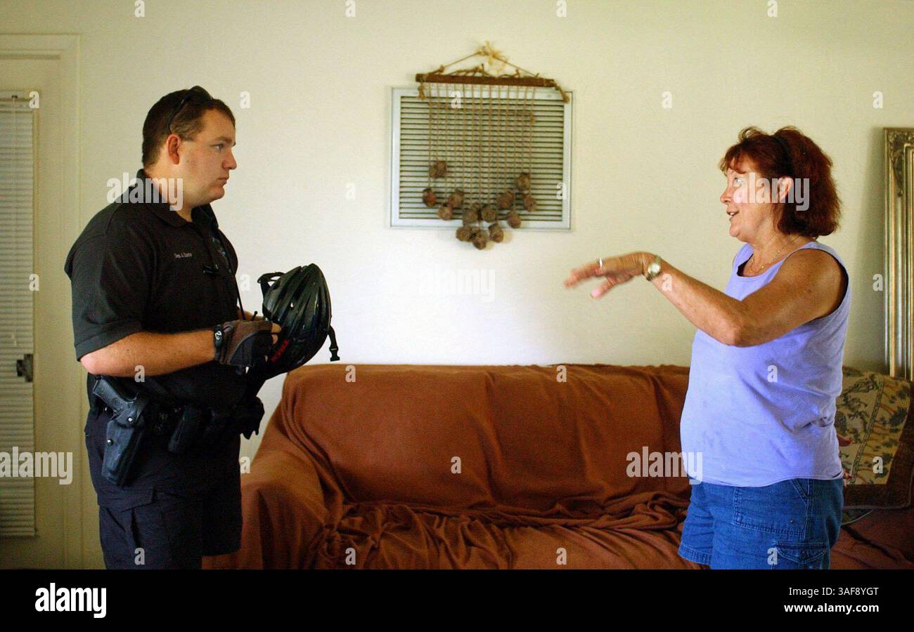 Agente di polizia della comunità Seminole, Dep. Adam Sarlo (cq) ascolta Wanda Koske (cq) sabato (8/16/03), mentre Koske descrive i problemi con i respingimenti che ripetutamente abbattono la sua recinzione nel quartiere Blossom Lake di Seminole. "Vorrei identificarli e farli cadere", afferma Farlo. Koske e suo marito sono stati vittime di un recente rash di furti, e di Farlo (immagine di credito: St Petersburg Times/ZUMAPRESS.com) Foto Stock
