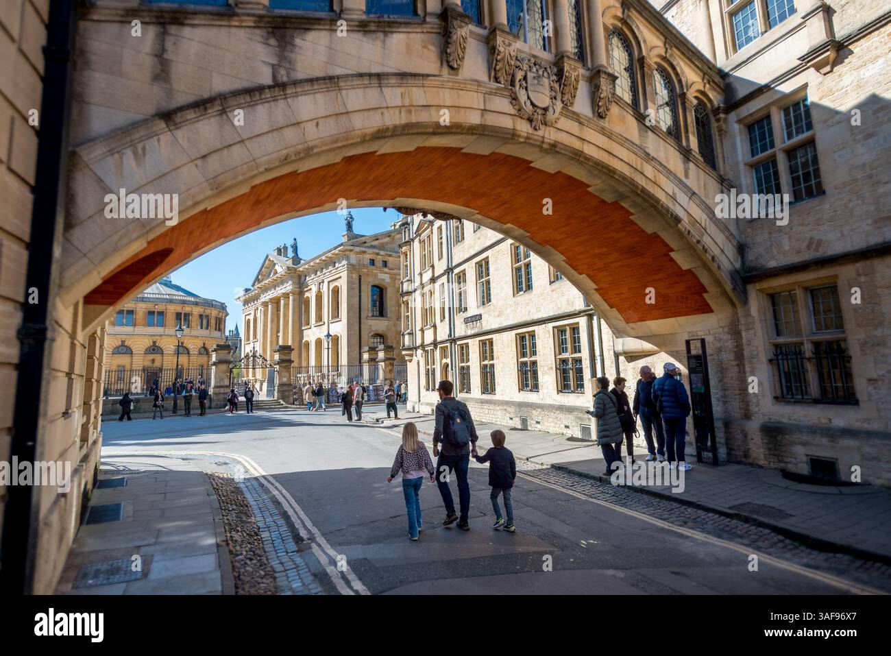 Padre e bambini camminano sotto l'Hertford Bridge (Ponte delle attrazioni) a Oxford, Regno Unito Foto Stock