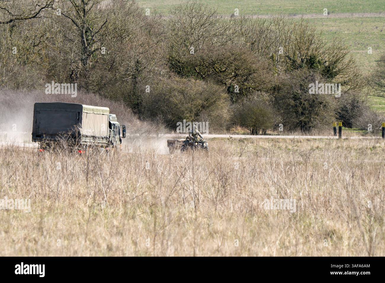 Camion multiuso MAN HX 6x6 dell'esercito britannico con rimorchio in movimento lungo una pista sterrata in campagna Foto Stock