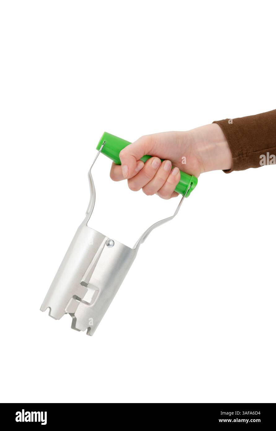 Tenere a mano una piantatrice a bulbo con una maniglia verde, isolata su sfondo bianco. Foto Stock