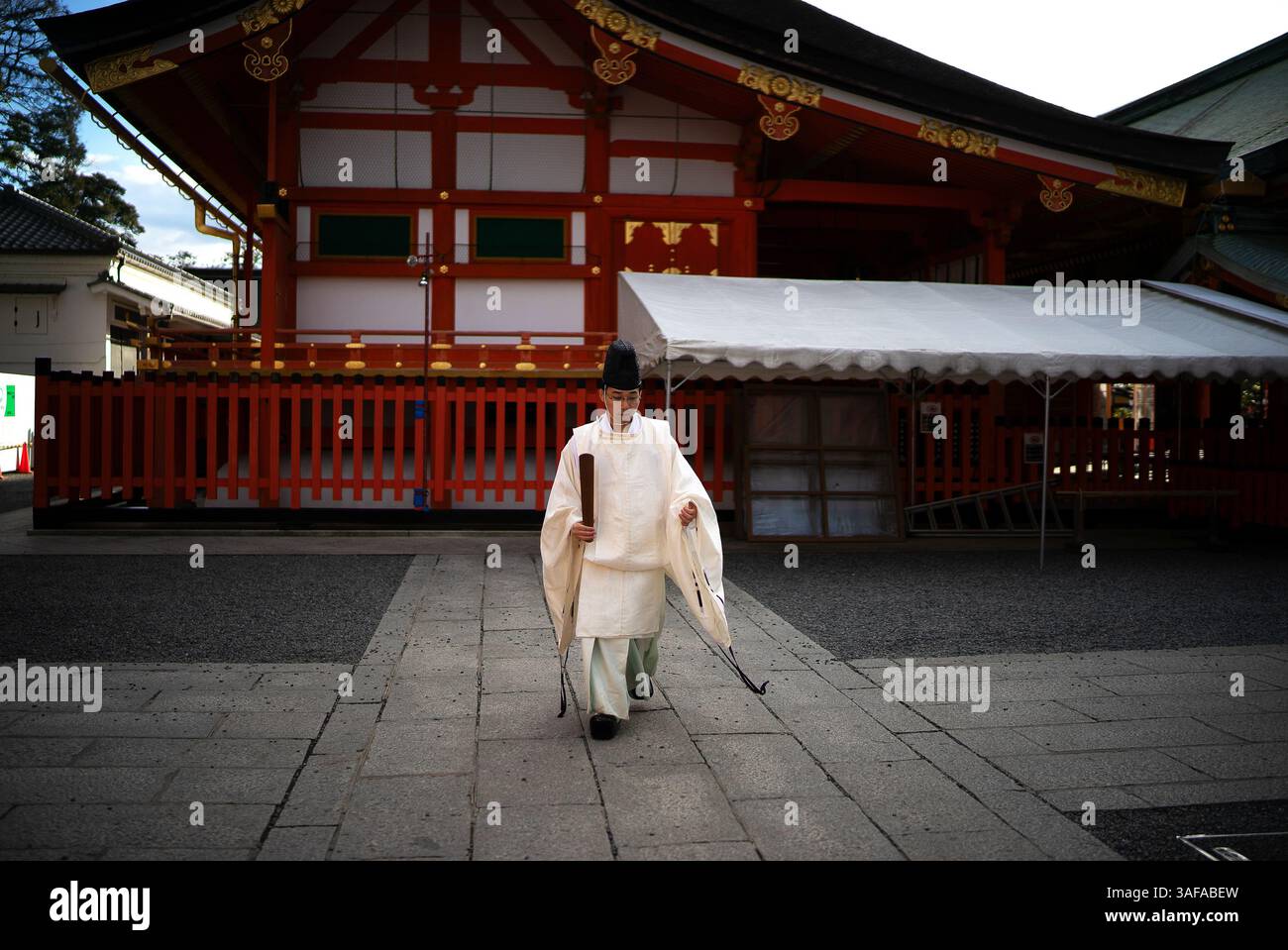 Sacerdote shintoista in abbigliamento tradizionale al Fushimi Inari Taisha, Kyoto, Un simbolo di rituali spirituali e patrimonio giapponese Foto Stock