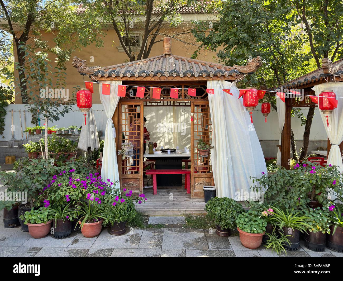 Un pittoresco gazebo cinese, splendidamente decorato con lanterne rosse e bandiere. Foto Stock