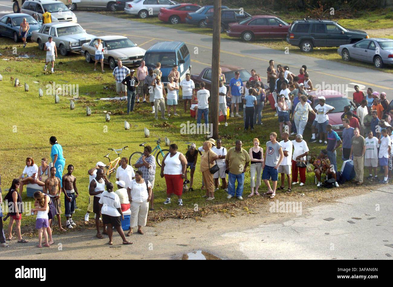 09/01/2005, Gulfport, signorina) L-R: Folle di auto e persone si allineano alla scuola media centrale di Gulfport in attesa che ghiaccio e acqua vengano dati via a coloro che ne hanno bisogno giovedì 1 settembre 2005 a Gulfport. Forniture come ghiaccio, acqua, benzina e cibo stanno diventando sempre più difficili da trovare nella zona, provocando lunghe code ovunque tali forniture siano distribuite. (Immagine di credito: St Petersburg Times/ZUMAPRESS.com) Foto Stock