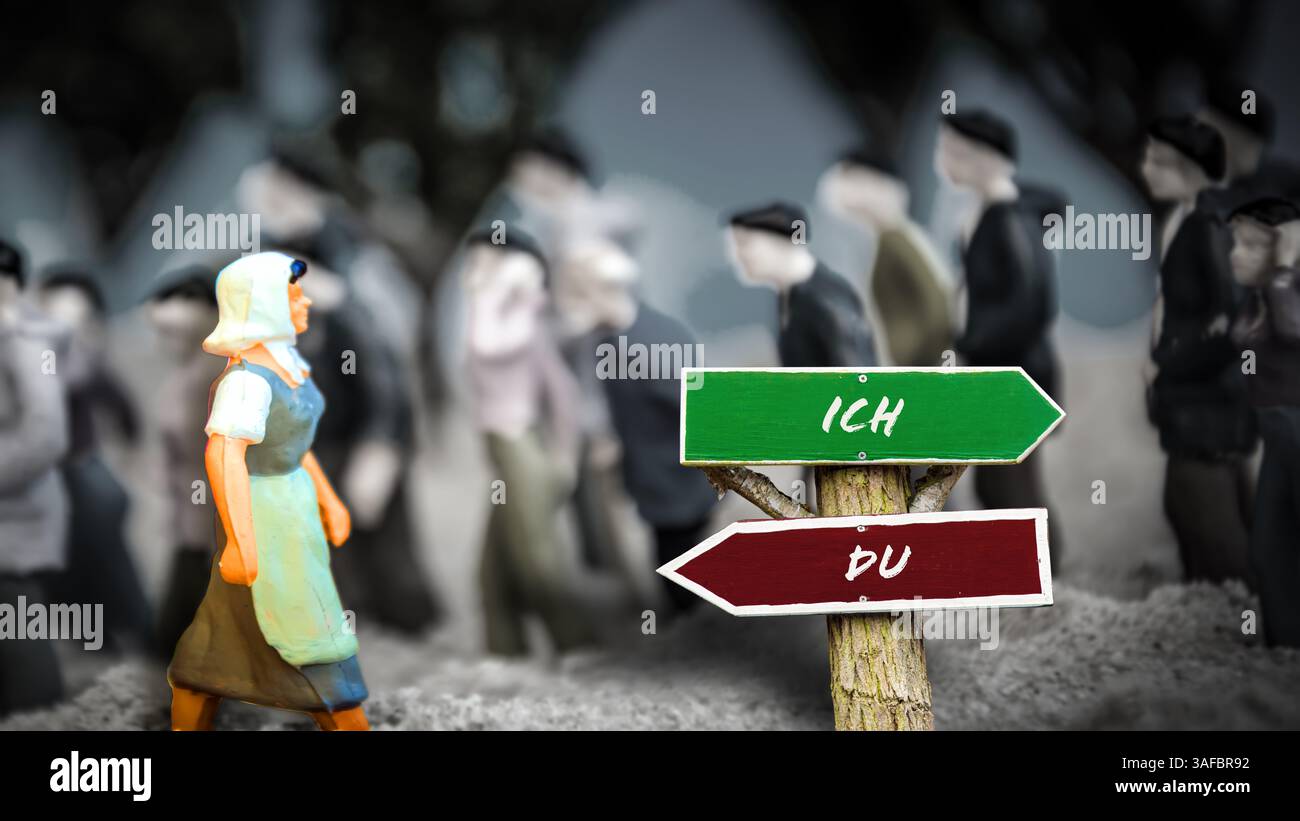 Un'immagine con un cartello che punta in due direzioni diverse in tedesco. Una direzione mi indica, l'altra ti indica. Foto Stock