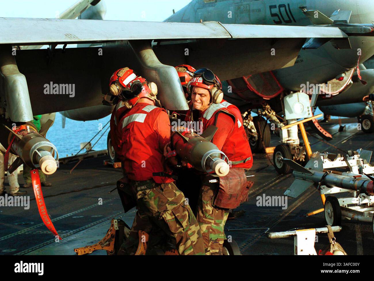 7 ottobre 2001; Mar Arabico; Ordinantemen dell'aviazione sulla USS Enterprise (CVN 65) forniture muscolari in atto come aeromobili pronti per missioni d'attacco contro obiettivi in Afghanistan, destinate a interrompere le operazioni terroristiche e ad attaccare le capacità militari del regime talibano. (Immagine di credito: ZUMA Press/ZUMAPRESS.com) Foto Stock