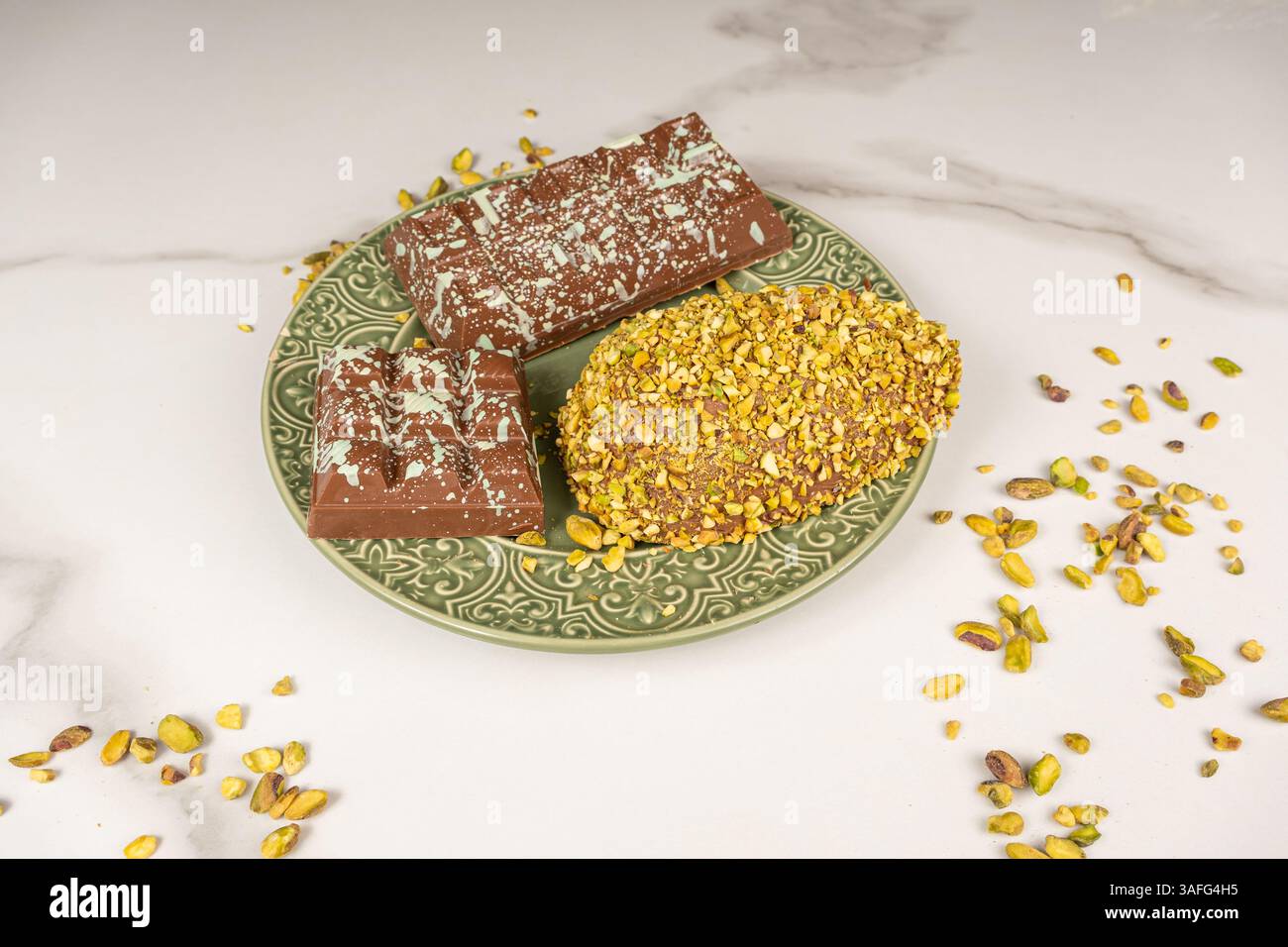 Uovo di Pasqua con pezzi di pistacchio e barretta di cioccolato. Foto Stock