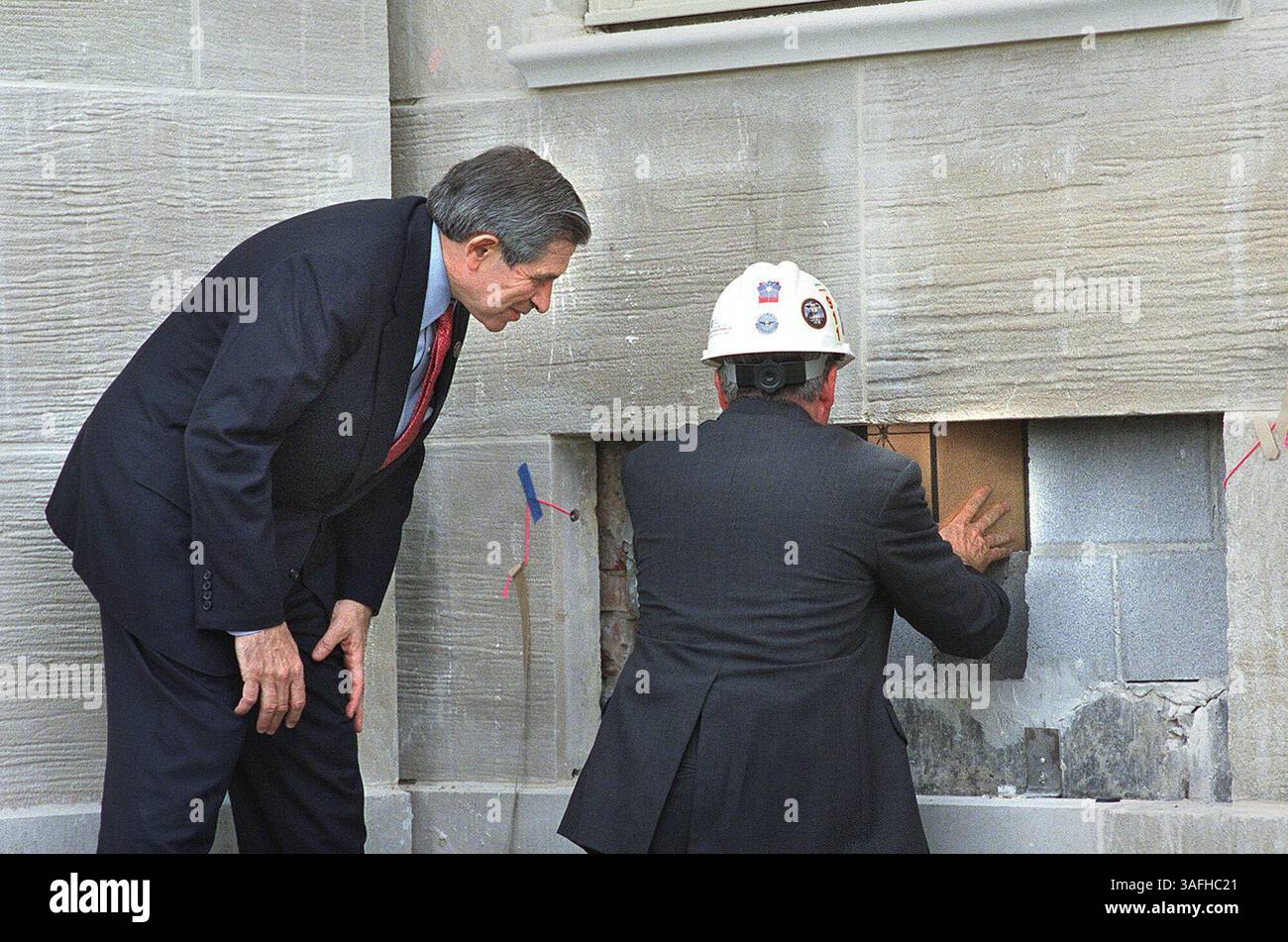 Il vice segretario alla difesa Paul Wolfowitz, a sinistra, guarda come Lee Evey, responsabile del programma di ristrutturazione del Pentagono, colloca una capsula di dedica dietro l'ultimo pezzo di pietra calcarea che completa la facciata occidentale del Pentagono, distrutta dall'attacco terroristico dell'11 settembre. Foto scattata martedì 11 giugno 2002. (Immagine di credito: The Washington Times/ZUMAPRESS.com) Foto Stock