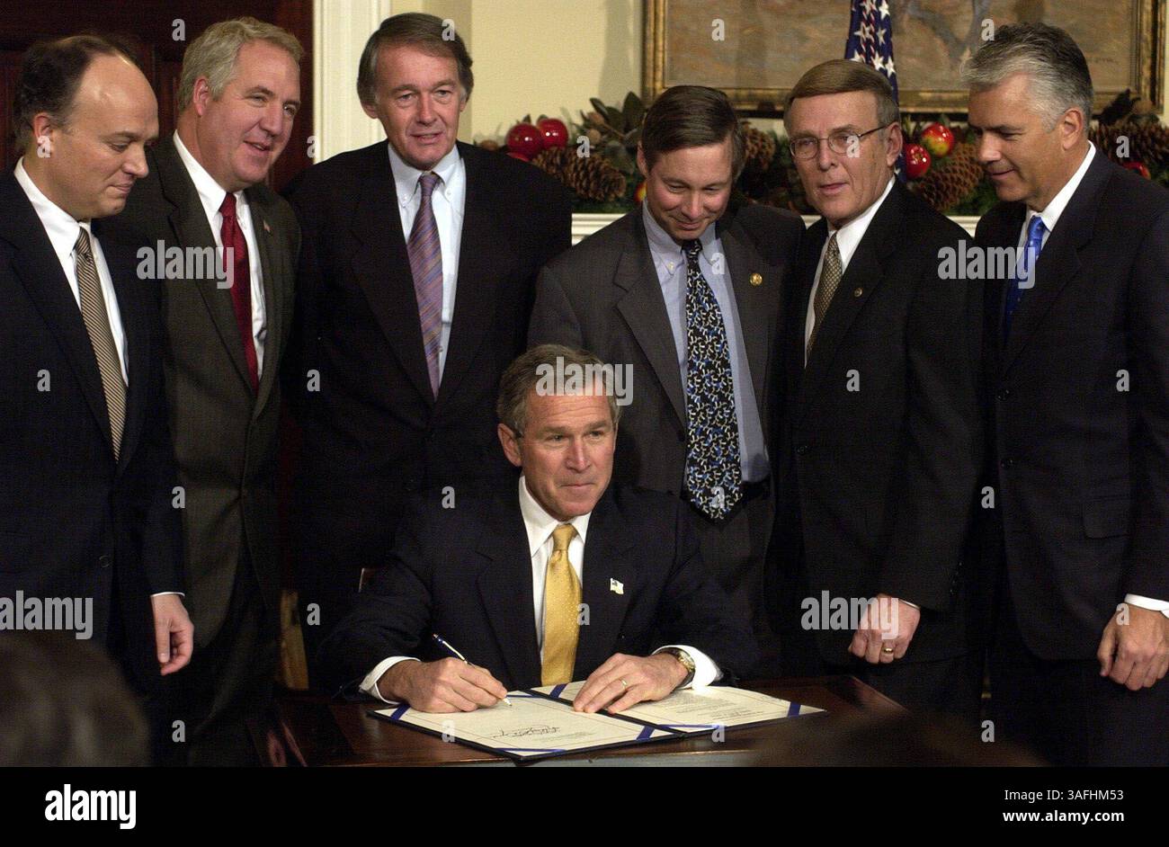 Il presidente George W. Bush sorride dopo aver firmato H.R. 3833, il Dot Kids Implementation Efficiency Act del 2002 nella sala Roosevelt alla Casa Bianca e poi risponde con forza alle domande e ai commenti dei giornalisti sull'Iraq, mercoledì 4 dicembre 2002. l-r, dietro POTUS ci sono, Sen. Peter Fitzgerald (R-il), Rep. Adam Schiff (D-CA), Rep. Edward Markey (D-ma), Rep. Fred Upton (R-mi), Sen. Bryon Dorgon (D-ND), Sen. John Ensign (Credit Image: The Washington Times/ZUMAPRESS.com) Foto Stock