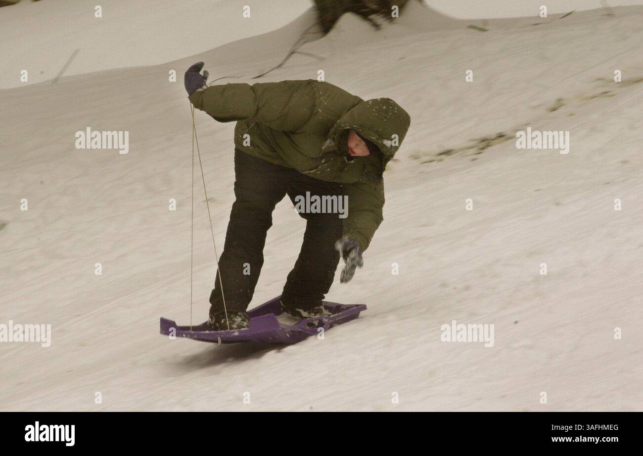 Spencer Williams, 14 anni, mantiene l'equilibrio mentre scivola giù dalla collina in piedi sulla sua slitta a Ridgeview Park nella contea di Fairfax giovedì mattina 5 dicembre 2002, durante la prima nevicata della stagione nell'area di Washington. Tutte le scuole della zona erano chiuse a causa del tempo. (Immagine di credito: The Washington Times/ZUMAPRESS.com) Foto Stock