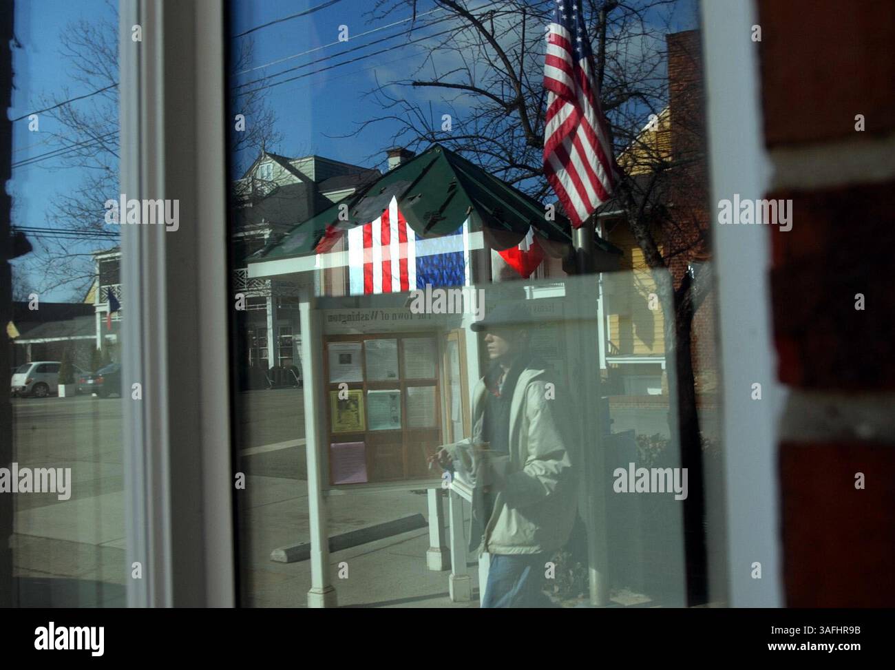 Mentre la bandiera degli Stati Uniti si trova a mezz'asta, un uomo passa davanti all'ufficio postale di Washington, Virginia, USA, domenica pomeriggio. 2 febbraio 2003, un giorno dopo l'esplosione dello Space Shuttle Columbia durante il suo atterraggio, uccidendo tutti e sette a bordo. (Immagine di credito: The Washington Times/ZUMAPRESS.com) Foto Stock