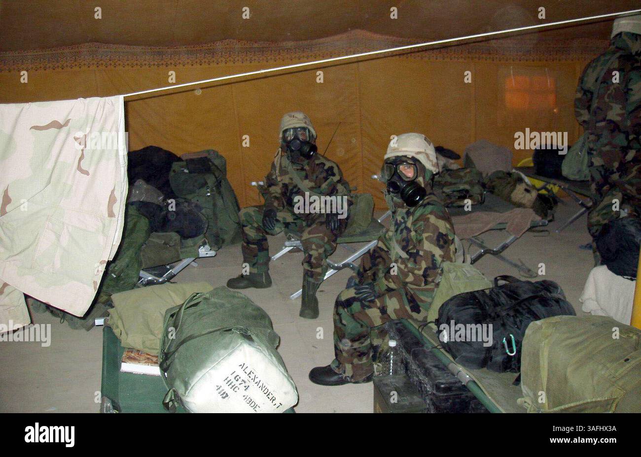 Due ufficiali femminili con la compagnia del quartier generale della brigata di aviazione della 4th Infantry Division sedettero il calore in completo equipaggiamento di protezione nucleare, biologico e chimico all'interno della loro tenda durante un allarme giovedì 3 aprile 2003. (Immagine di credito: The Washington Times/ZUMAPRESS.com) Foto Stock