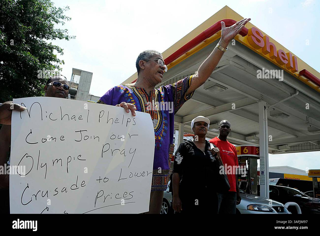 Rocky Twyman, che ha iniziato la preghiera al movimento Pump diversi mesi fa, è venuto alla stazione Shell di Upshur e Georgia Ave. NW con i sostenitori mercoledì 13 agosto 2008 per ringraziare Dio per i prezzi del gas più bassi. Qui ha un cartello che invita il nuotatore olimpico Michael Phelps ad unirsi al movimento. Il signor Twyman sta pregando per abbassare i prezzi del gas, e dice che il suo movimento sta funzionando e ha raccolto circa 300 sostenitori in tutta la nazione. Evidentemente Jay Leno ha sentito parlare del movimento e lo ha deriso nel suo show alla fine di luglio, quindi ora il signor Twyman sta invitando il signor Leno a venire a pregare con lui. Lui Foto Stock