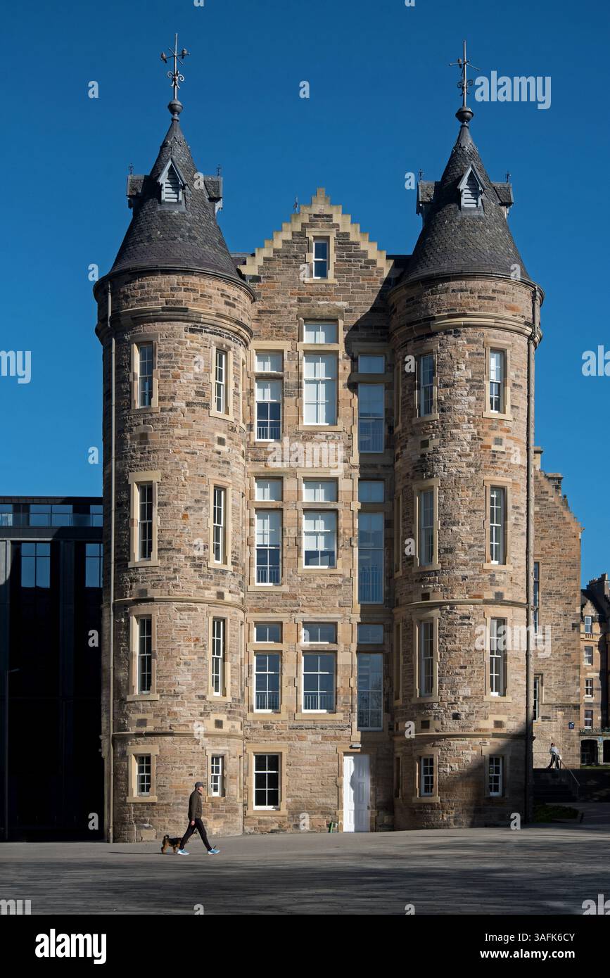 Uomo e cane che camminano presso l'Edinburgh Futures Institute dell'Università di Edimburgo, ex Old Royal Infirmary. Foto Stock