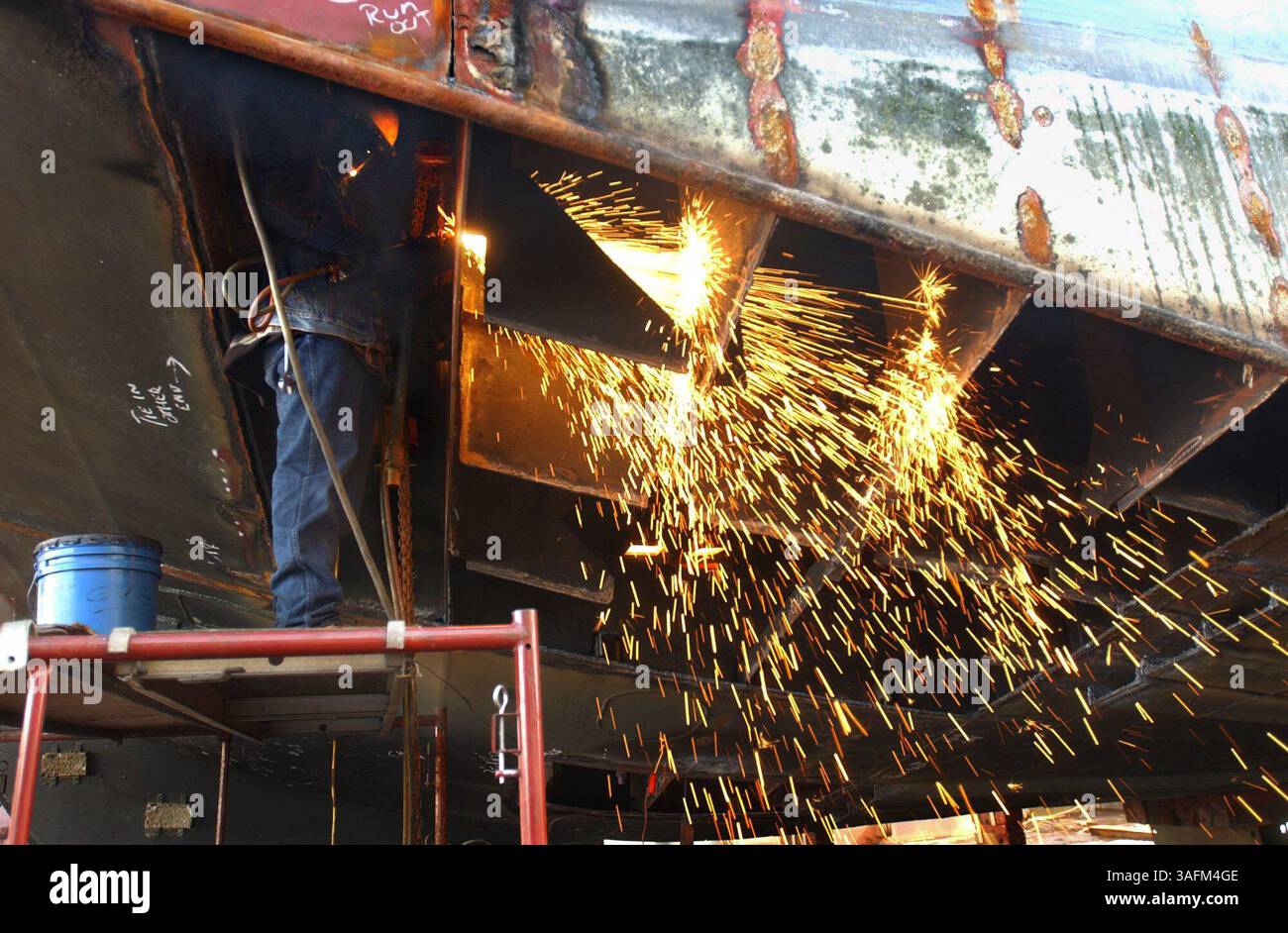 2) al Wright (cq), un "addetto alla riparazione" con Gulf Marine Repair, utilizza una torcia per tagliare la struttura di supporto dello scafo di una grande nave in bacino di carenaggio per la riparazione il lunedì (immagine di credito: St Petersburg Times/ZUMAPRESS.com) Foto Stock