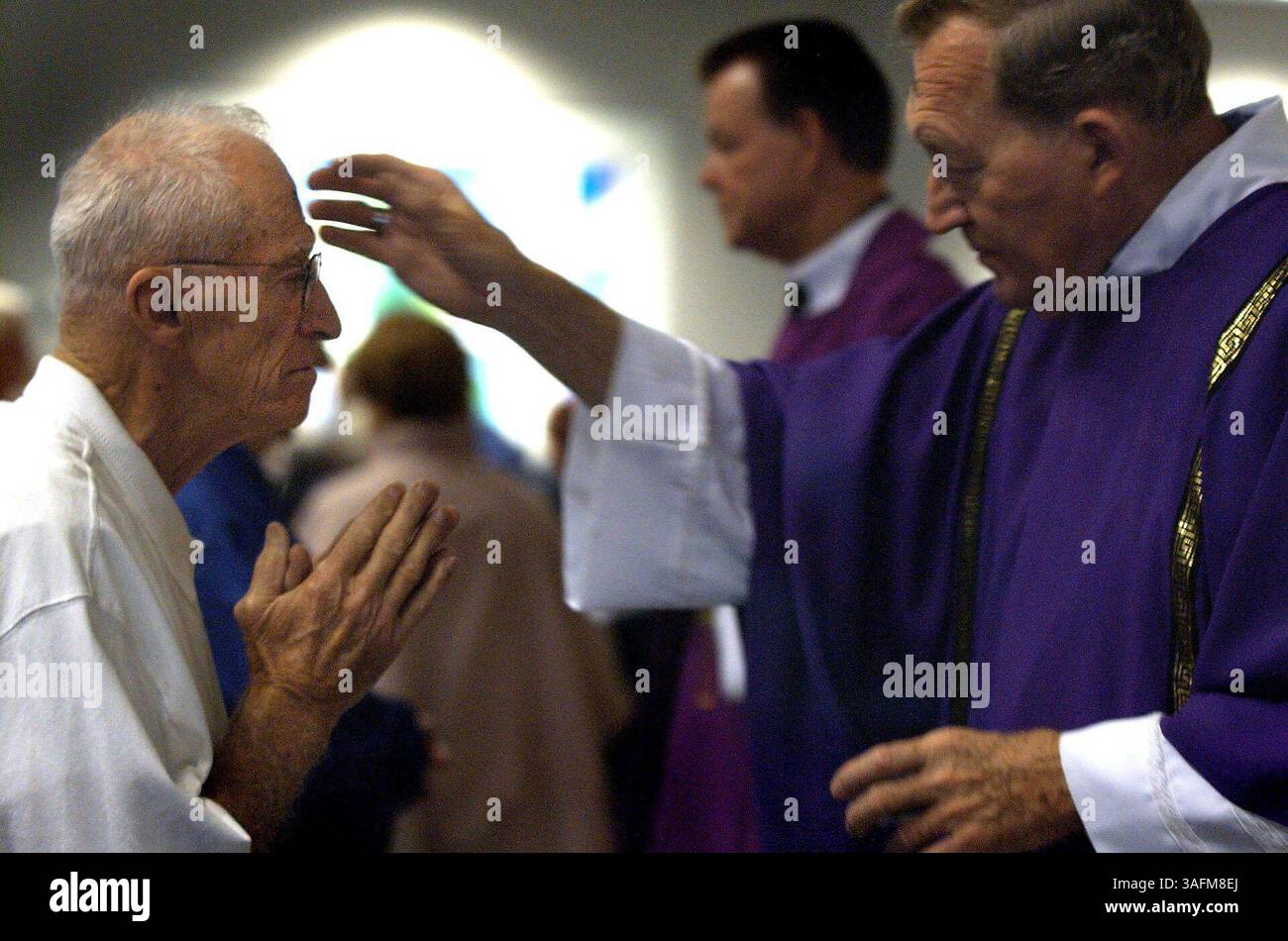 Edward J. McDonough riceve ceneri in segno di croce da Decon Mel Dunphy presso la chiesa cattolica St. Thomas Aquinas a New Port Richey mercoledì 2/25/04. Il nome ufficiale dei giorni è il giorno delle ceneri e cade quaranta giorni prima del venerdì Santo. La croce simboleggia la morte e quindi ci ricorda la nostra mortalità. Le ceneri sono fatte bruciando fronde di palme che sono state salvate dalla domenica delle Palme dell'anno precedente e sono state benedette da un sacerdote. (Immagine di credito: St Petersburg Times/ZUMAPRESS.com) Foto Stock