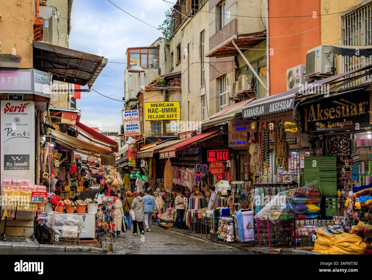 Istanbul, Turchia - 9 novembre 2023: Vivace e tradizionale bazar di strada con molti negozi che espongono merci e folle di persone che fanno shopping Foto Stock
