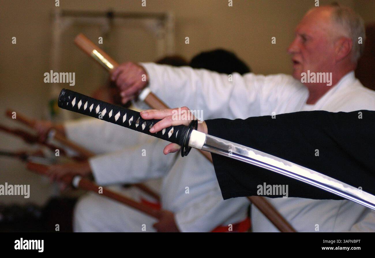 19/03/2005, Spring Hiil) FOTO 2: Barbara Graves (CQ Black Sleeve) disegna la sua katana, o spada lunga giapponese, durante le lezioni presso Tora No Mon (CQ) Martial Arts Academy fuori U.S. 19 a Spring Hill. Altri studenti usavano una spada di legno per esercitazioni, chiamata bokken. Jeff Driscoll (CQ), 43, di Pottsville, Penn., insegnò il seminario su Muso Jikiden Eishin-Ryu Iaijutsu, o la spada faccia a faccia. . RIEPILOGO DELLA STORIA: Durante il fine settimana, studenti di arti marziali di tutte le età e stili sono venuti a un raduno gratuito ospitato da Eddie Clingo e Tora No Mon (Credit Image: St Petersburg Times/ZUMAPRESS.com) Foto Stock