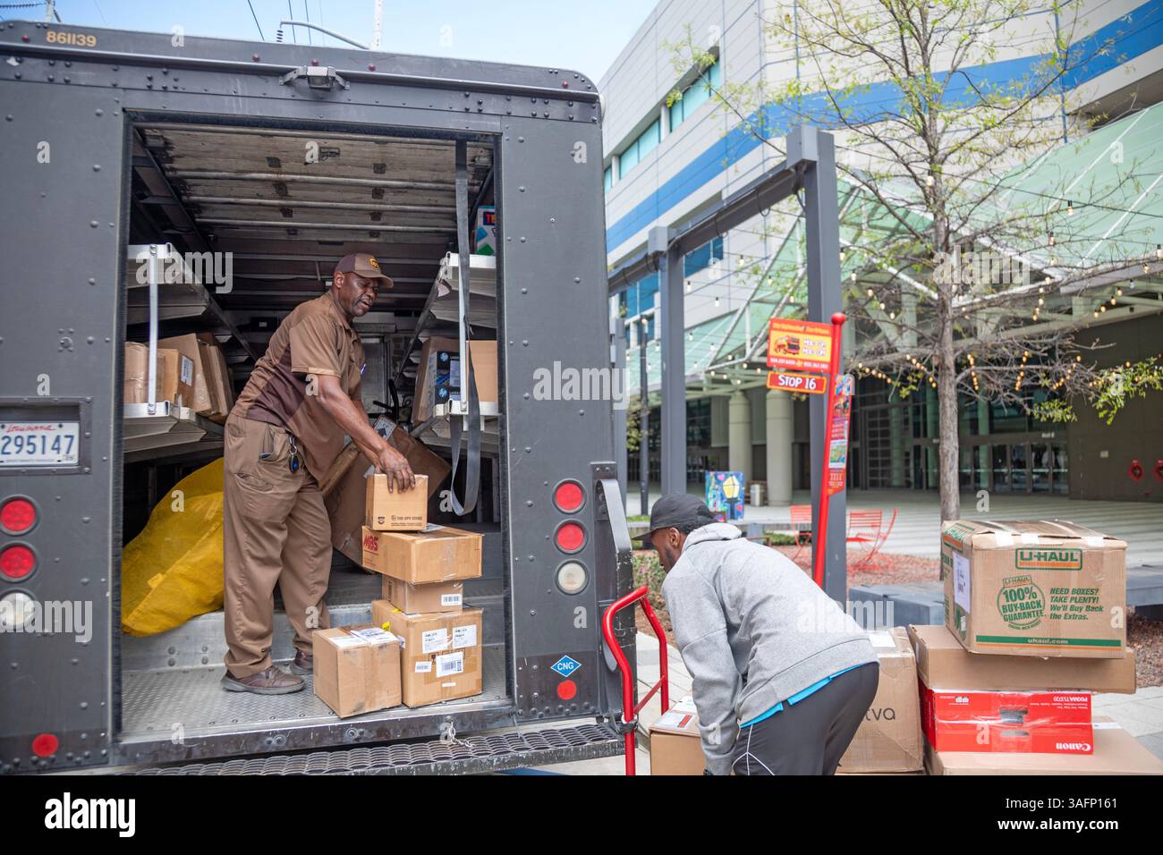 New Orleans, Louisiana - Un conducente della United Parcel Service e un assistente che caricano i pacchi in un "package car" al New Orleans Convention Center. Il truc Foto Stock