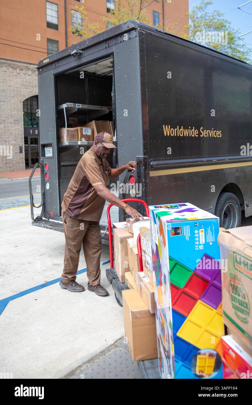 New Orleans, Louisiana - Un conducente della United Parcel Service carica i pacchi nella sua "package car" al New Orleans Convention Center. Il suo veicolo è POW Foto Stock