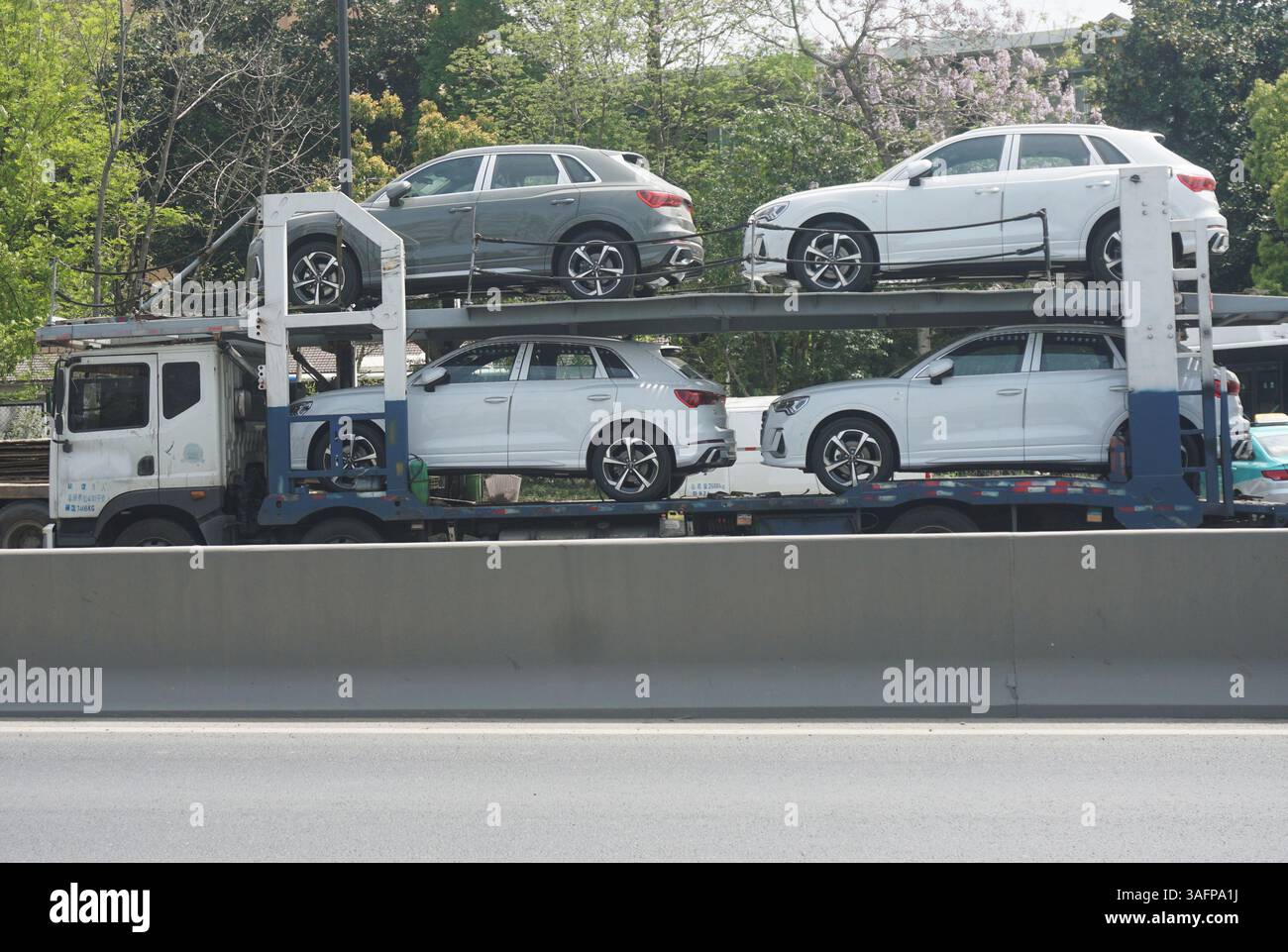 HANGZHOU, CINA - 7 APRILE 2025 - i camion che trasportano auto Audi guidano su una strada a Hangzhou, provincia di Zhejiang, Cina il 7 aprile 2025. Il 7 aprile, a causa dell'aumento delle tariffe sulle auto importate annunciato dal presidente degli Stati Uniti Trump, la società tedesca Audi Automobile ha deciso di sospendere la consegna di nuove auto ai concessionari statunitensi. Audi ha detto che tutti i veicoli che arrivano negli Stati Uniti dopo il 2 aprile saranno temporaneamente trattenuti e non saranno consegnati ai concessionari. Foto Stock