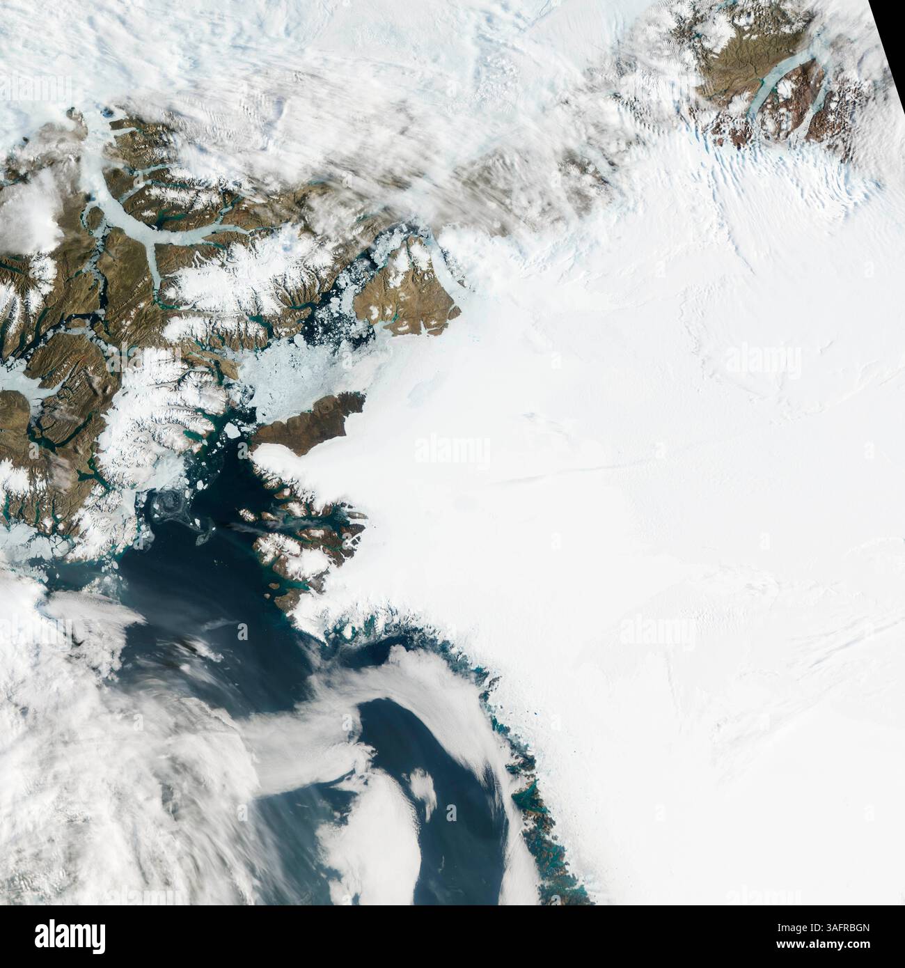 19 luglio 2012 - Ghiacciaio Petermann, Groenlandia - il Ghiacciaio Petermann macina e scivola verso il mare lungo la costa nord-occidentale della Groenlandia, terminando in una gigantesca lingua di ghiaccio galleggiante. Come altri ghiacciai che terminano nell'oceano, Petermann allontana periodicamente gli iceberg. Un enorme iceberg, o isola di ghiaccio, si ruppe al largo del ghiacciaio Petermann nel 2010. Quasi due anni dopo, un altro pezzo di ghiaccio si è liberato. Il 17 luglio, Aqua spiò un'apertura più ampia tra il ghiacciaio e l'iceberg, così come una rottura del ghiaccio più sottile a valle. L'iceberg sembra aver fatto un leggero contatore Foto Stock