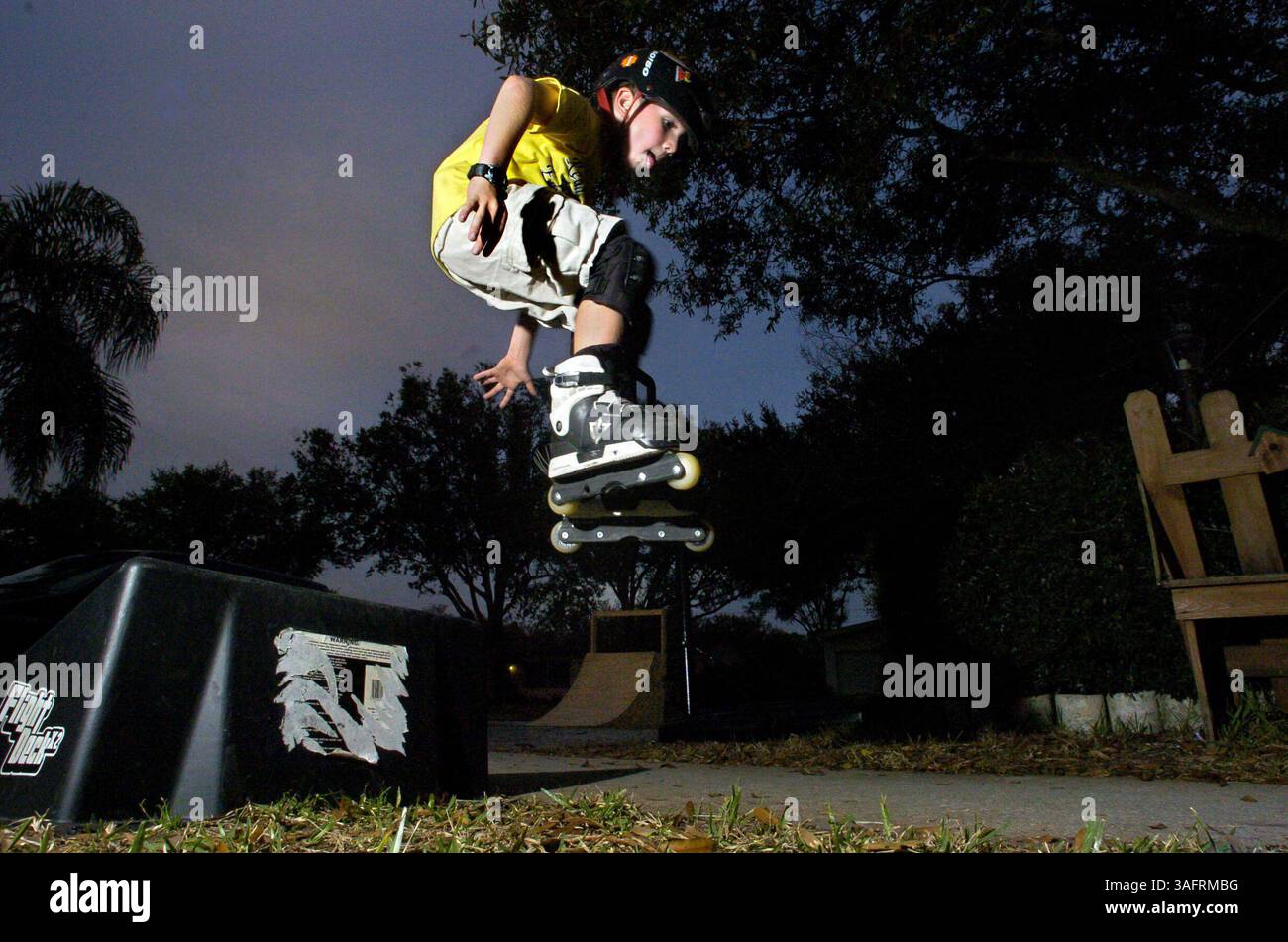 DIDASCALIA: (Largo 1/11/2006) Alex Brillant, 7 anni, salpa da una rampa mentre pattina davanti alla sua casa largo mercoledì sera, 11 gennaio 2006. Il padre di Alex, Joe, che lavora come creatore di armadietti e spesso pattina con Alex, ha realizzato una rampa di pattinaggio in legno come regalo di Natale (raffigurato in sottofondo) e Alex la usa fedelmente ogni giorno dopo la scuola, secondo sua madre, Kristin. "Ieri sera ho trovato le ginocchia nel suo letto", ha detto. Anche se Alex pattina quasi ogni giorno, insiste che non pratica molto. "Ho solo pattinato molto", ha detto. (Immagine di credito: St Petersburg Times/ZUMAPRESS.com) Foto Stock