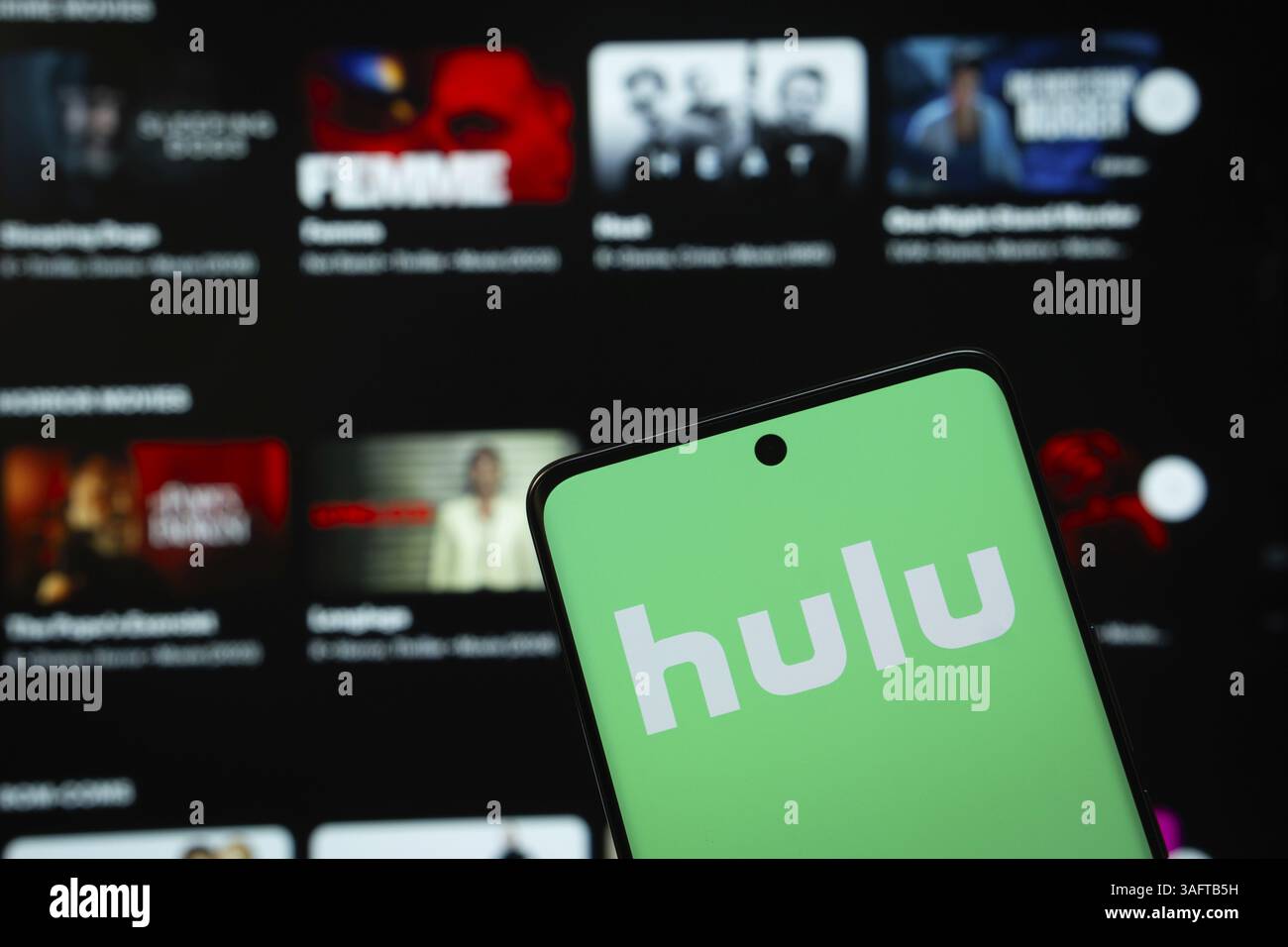 Il logo di hulu viene visualizzato sullo schermo di uno smartphone e il sito Web di hulu è visibile sullo schermo di un computer sullo sfondo Foto Stock