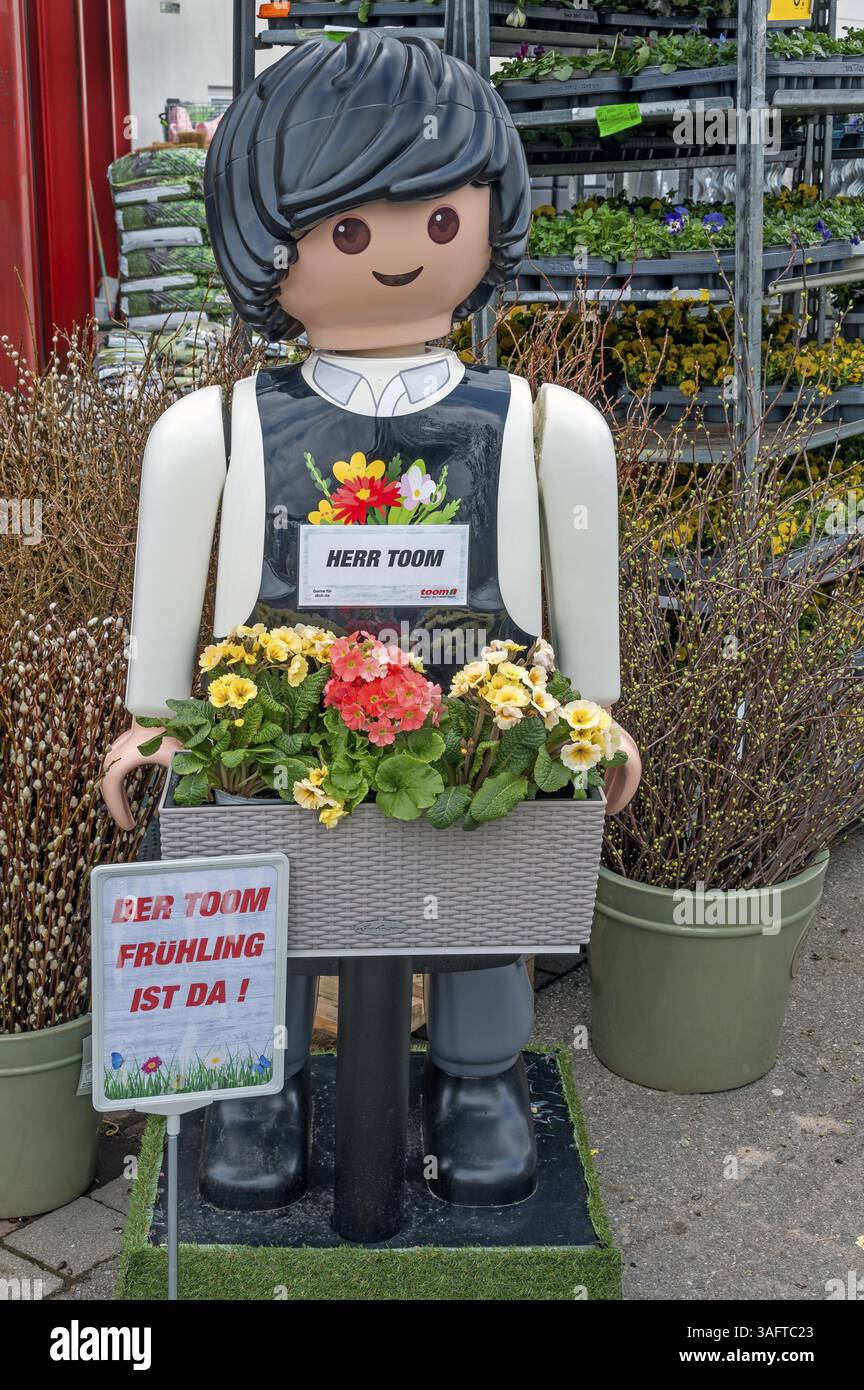 Uomo di plastica con cesto di fiori, MR Plastic Toom davanti a un negozio fai da te, Allgaeu, Svevia, Baviera, Germania, Europa Foto Stock