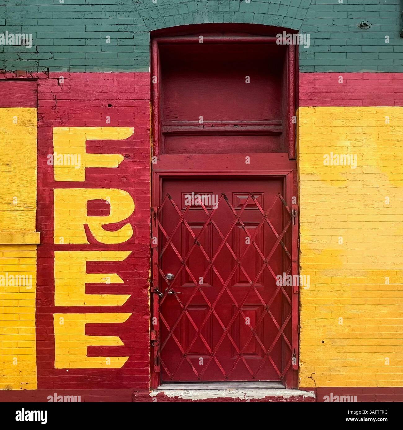 Un audace e colorato negozio di Chicago con vernice rossa e verde e un grande cartello "GRATUITO", tipico della pubblicità delle piccole imprese locali - Immagine stock catturata con smartphone