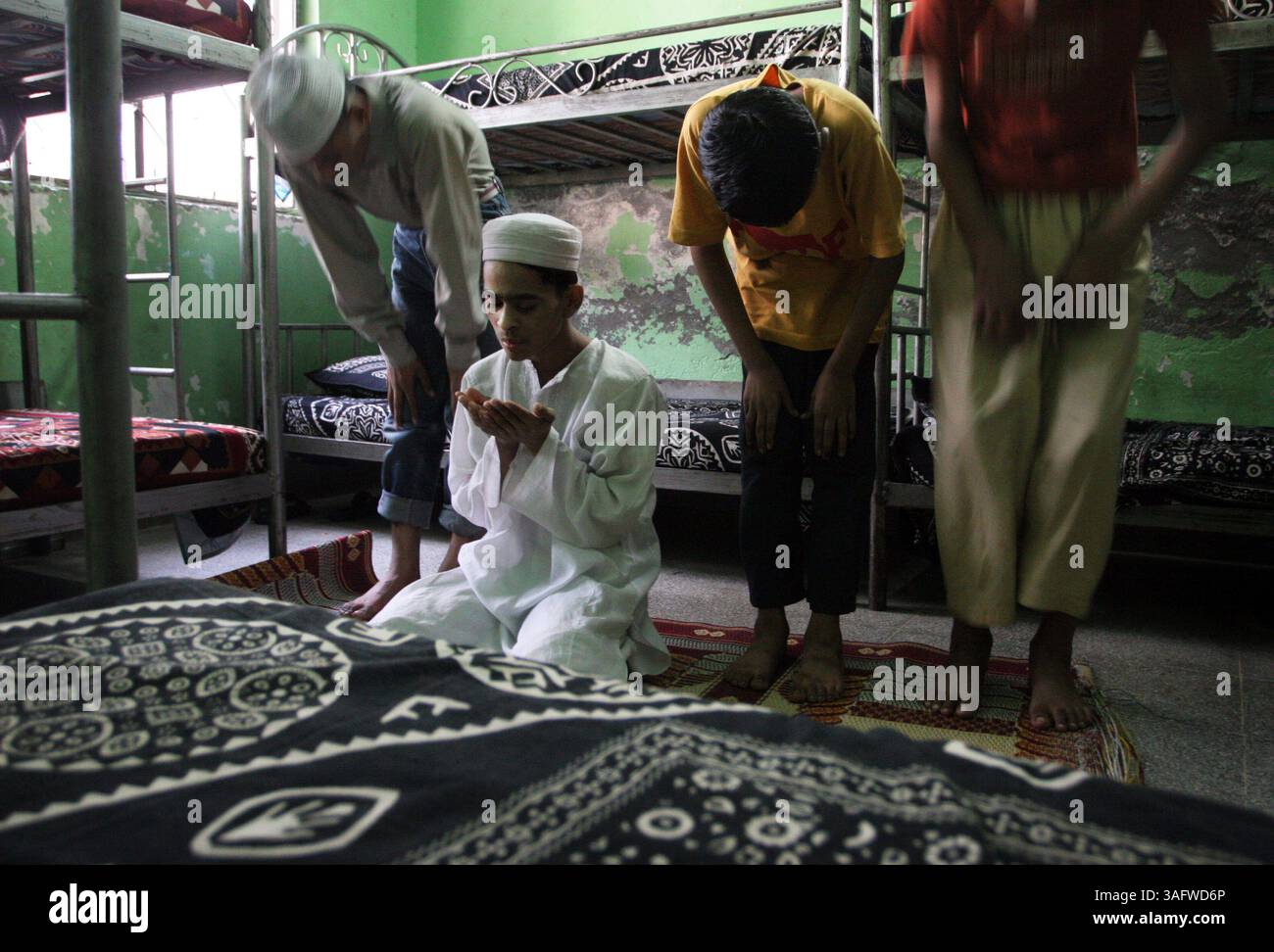 Lahore 10/28/2006).Hassan Ali, che non è sicuro se abbia 14 o 15 anni, prega con altri ex fantini di cammello nella stanza che condividono al Centro servizi di protezione bambini a Lahore. Ali fu venduto da bambino come fantino cammello all'ippodromo di nad al Sheba, alla periferia di Dubai. Ora vive con i servizi di protezione dell'infanzia a Lahore, Pakistan. I bambini con cui condivide la sua camera erano anche fantini di cammello a Dubai. (Immagine di credito: St Petersburg Times/ZUMAPRESS.com) Foto Stock