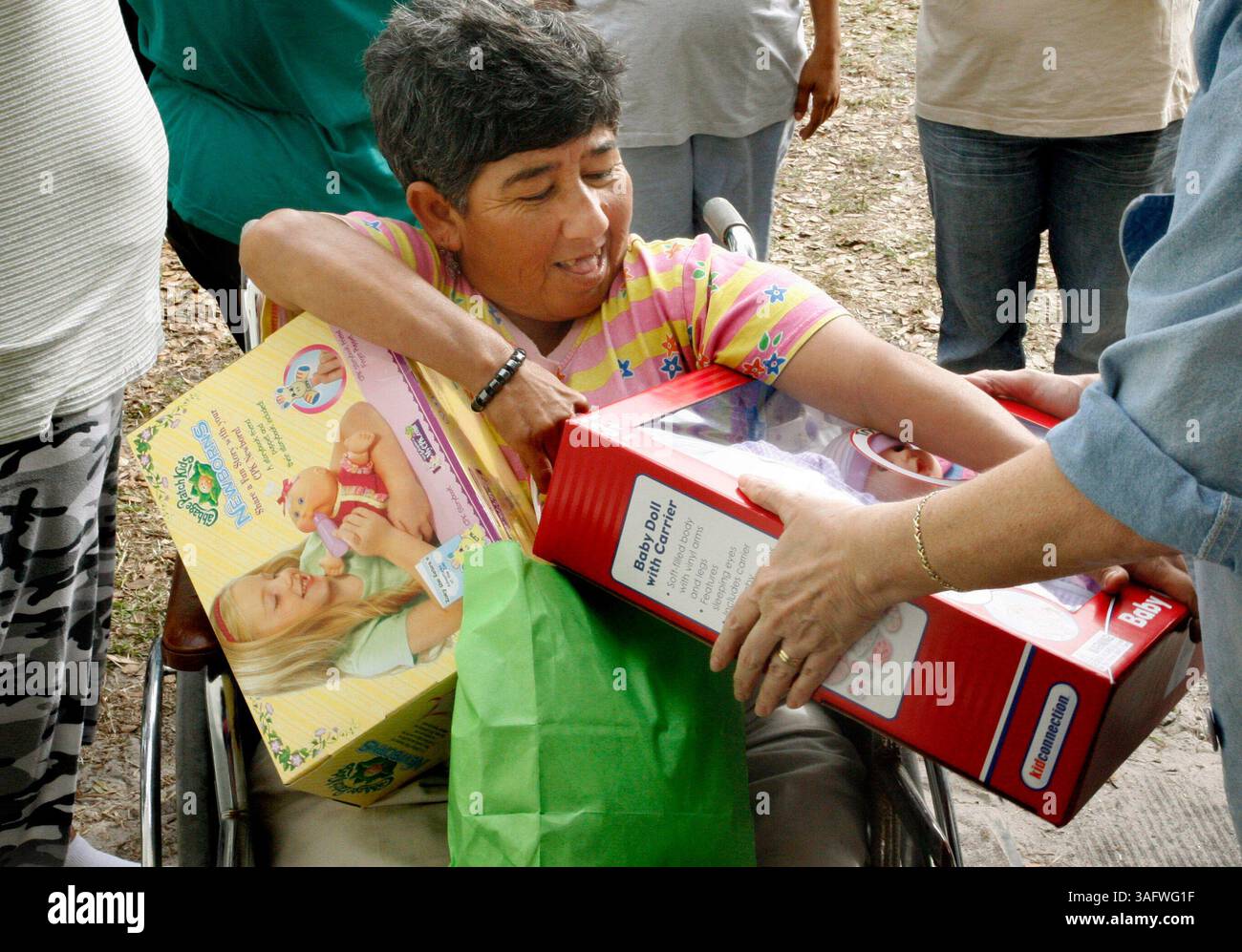 4 di 5.DIDASCALIA: (12/21/06 - TAMPA): (4) Emilia Aquirra (parente cq / 37 anni) riceve la sua bambola da Laura Cruz (cq / a destra), durante l'evento annuale di donazione alla Good Samaritan Mission di Wimauma giovedì (immagine di credito: St Petersburg Times/ZUMAPRESS.com) Foto Stock