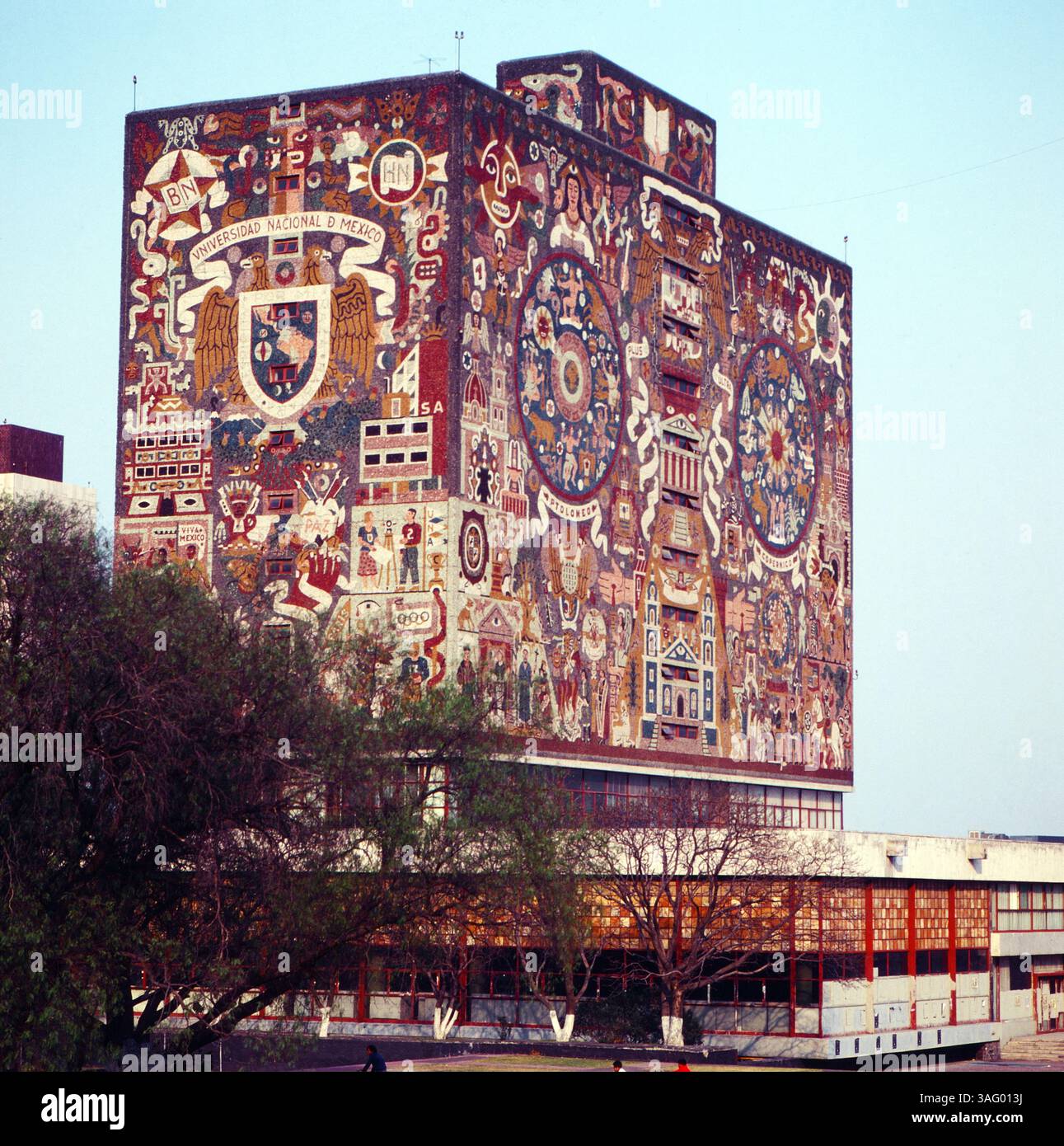 DAS berühmte Bibliotheksgebäude der UNAM (Universidad Nacional Autonoma de Mexico) in Mexiko-Stadt, bekannt für seine monumentalen Wandmalereien des Künstlers Juan o'Gorman. Die kunstvolle Fassade zeigt historische und kulturelle symbole Mexikos und gehört zum UNESCO-Weltkulturerbe, um 1985. Foto Stock