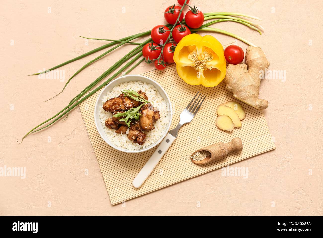 Gustoso pollo agrodolce con riso nel recipiente, verdure e forchetta su sfondo beige Foto Stock
