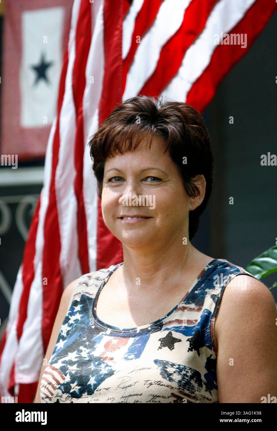2 di 2.DIDASCALIA (TAMPA - 8/12/07): (2) Jo Ann Ross (cq / 51 anni), fuori casa a Plant City, si erge accanto alla sua bandiera americana e alla bandiera a stella singola che rappresenta una persona cara in guerra. Entrambi i suoi figli stanno prestando servizio in Iraq e sua nuora ha servito due turni di servizio. Vedi di più su Ross e la sua famiglia dell'esercito su (immagine di credito: St Petersburg Times/ZUMAPRESS.com) Foto Stock