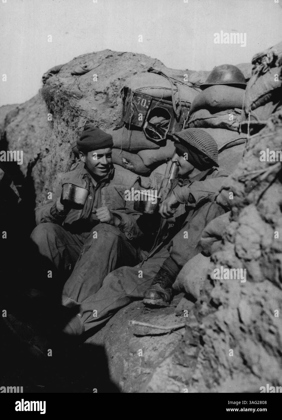 Con la "Black Watch" in Corea - a soli 500 metri dalle posizioni cinesi, ma a queste due "Tomme" britanniche non importava di meno, a patto che abbiano un sacco di buon tè vecchio per farli andare avanti. Sono (da sinistra a destra) il T. Barrie privato di Stirlingshire, Scozia e il D. Page privato di Dundee, Scozia, che si gusta il tè dalle loro casse. Foto in prima linea scattate tre giorni dopo il 1 ° Battn. La posizione degli orologi neri in Corea era stata attaccata in forza dai cinesi. 30 novembre 1952. (Foto di Paul Popper, Paul Popper Ltd.). Foto Stock