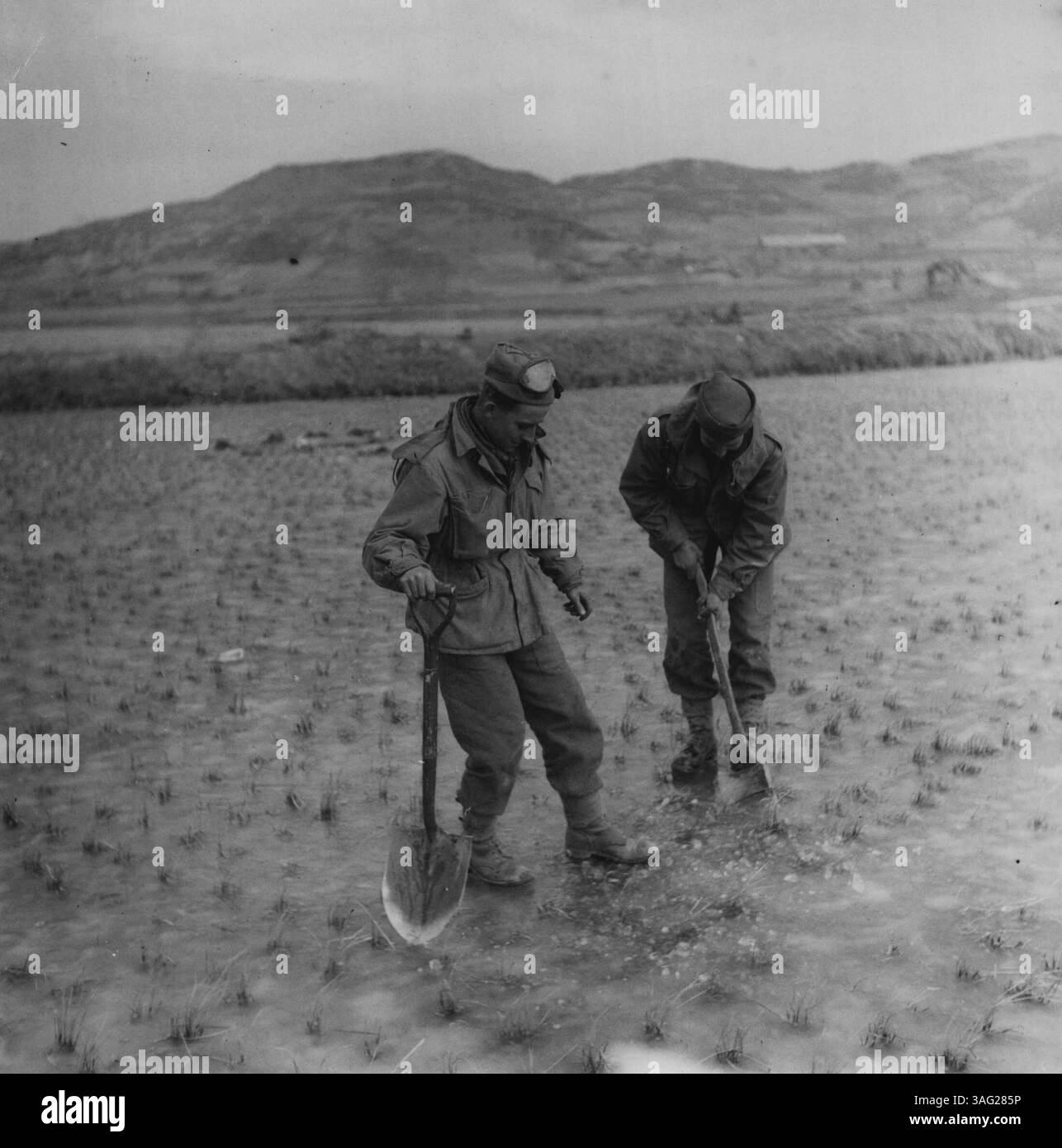 Uomini del Middlesex sulla zona ghiacciata di Paddy Fields - Pakchon. Le condizioni climatiche fredde non hanno visto preoccupare questi uomini. Hanno fatto un buco per vedere "solo per vedere come si pensa che fosse". 4 dicembre 1950. Foto Stock