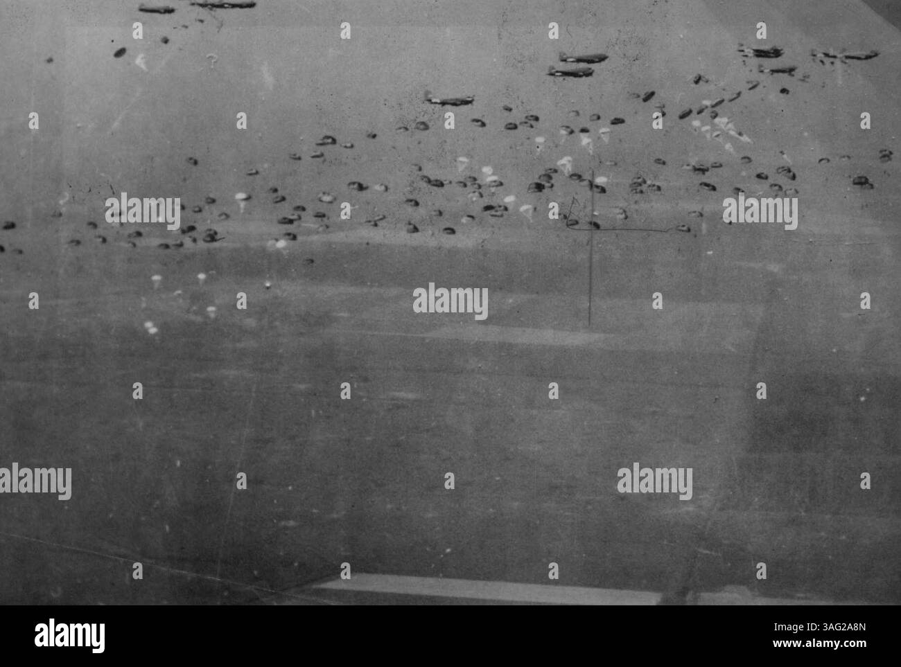 Paracadutisti e rifornimenti in parapetto fuoriescono da cieli pieni di scaglie nella zona di lancio di Rees-Wesel, mentre la più grande invasione aerea di sempre sta per iniziare. Un'armata di oltre 1.500 aerei portaerei schiantò 40.000 paracadutisti e fanteria trasportata da alianti per guidare l'attraversamento del Reno della Second Army britannica. 27 marzo 1945. (Foto di Topical Press) Foto Stock