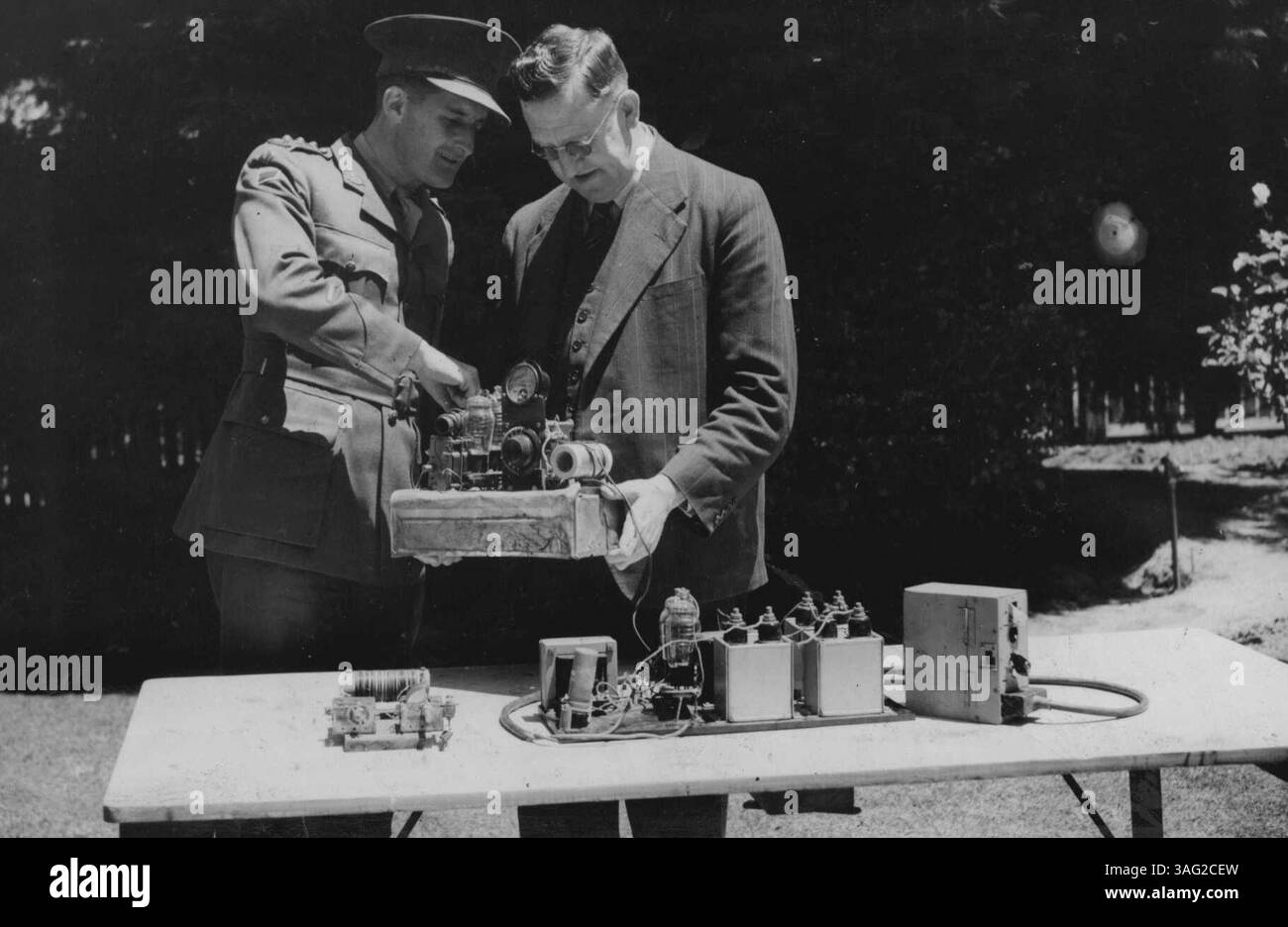 Il Ministro dell'informazione, Sig. Calwell, con la collaborazione del Ministro dell'Esercito, Sig. Forde, ha disposto che il set wireless di emergenza, affettuosamente noto come "Winnie the War Winner" attraverso il quale i guerriglieri Timor hanno stabilito contatti con la terraferma e assicurato cibo e rifornimenti dovrebbe essere ascoltato da tutto il popolo australiano. Sarà incorporato in un programma speciale di trasmissione su stazioni radio commerciali alle 9,15 di domenica prossima sera. Un ufficiale dell'Australian Corps of Signals e' qui visto che spiega il meccanismo del set al signor Calwell. 1° dicembre 1943. Foto Stock