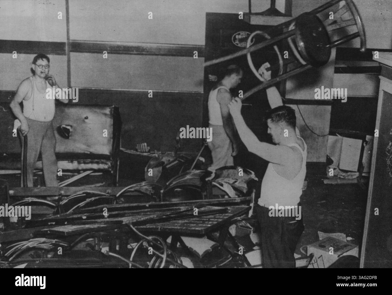 Un grande settore delle operazioni di gioco d'azzardo di Capone è stato in difficoltà ultimamente. Chicago ospita normalmente 1.500 centri di villeggiatura con manuali ippici, che spaziano da due a quattro camere sul retro a sale con soffitti alti Lars on the Nags ogni 24 ore. Dall'estate scorsa, il procuratore statale Thomas J. Courtney (i cui uomini sopra stanno distruggendo un manuale di Chicago) ha avuto una faida con i suoi compagni democratici, il capo Pat Nash. 14 gennaio 1939. Foto Stock