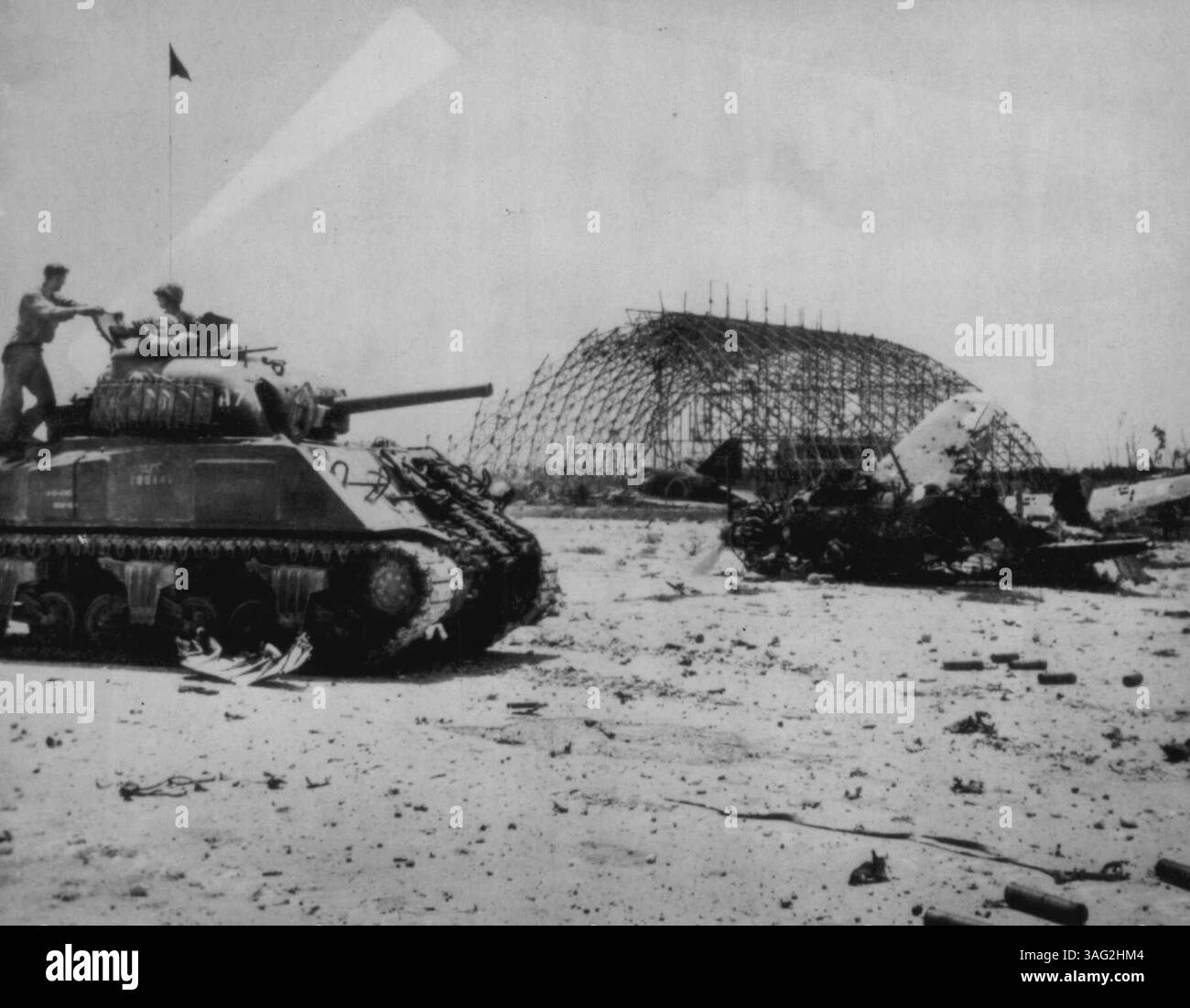 Marines Survey Damage to Peleliu Airfield -- tre Marines statunitensi rilevano i danni alle installazioni nemiche sul campo di aviazione sull'isola di Pelelieu nel gruppo Palau, provocati da bombardamenti navali e aerei pre-invasione, mentre prendono posizione nel loro carro armato sullo sfondo di aerei Jap e un manager. 25 settembre 1944. (Foto di Associated Press Photo). Foto Stock