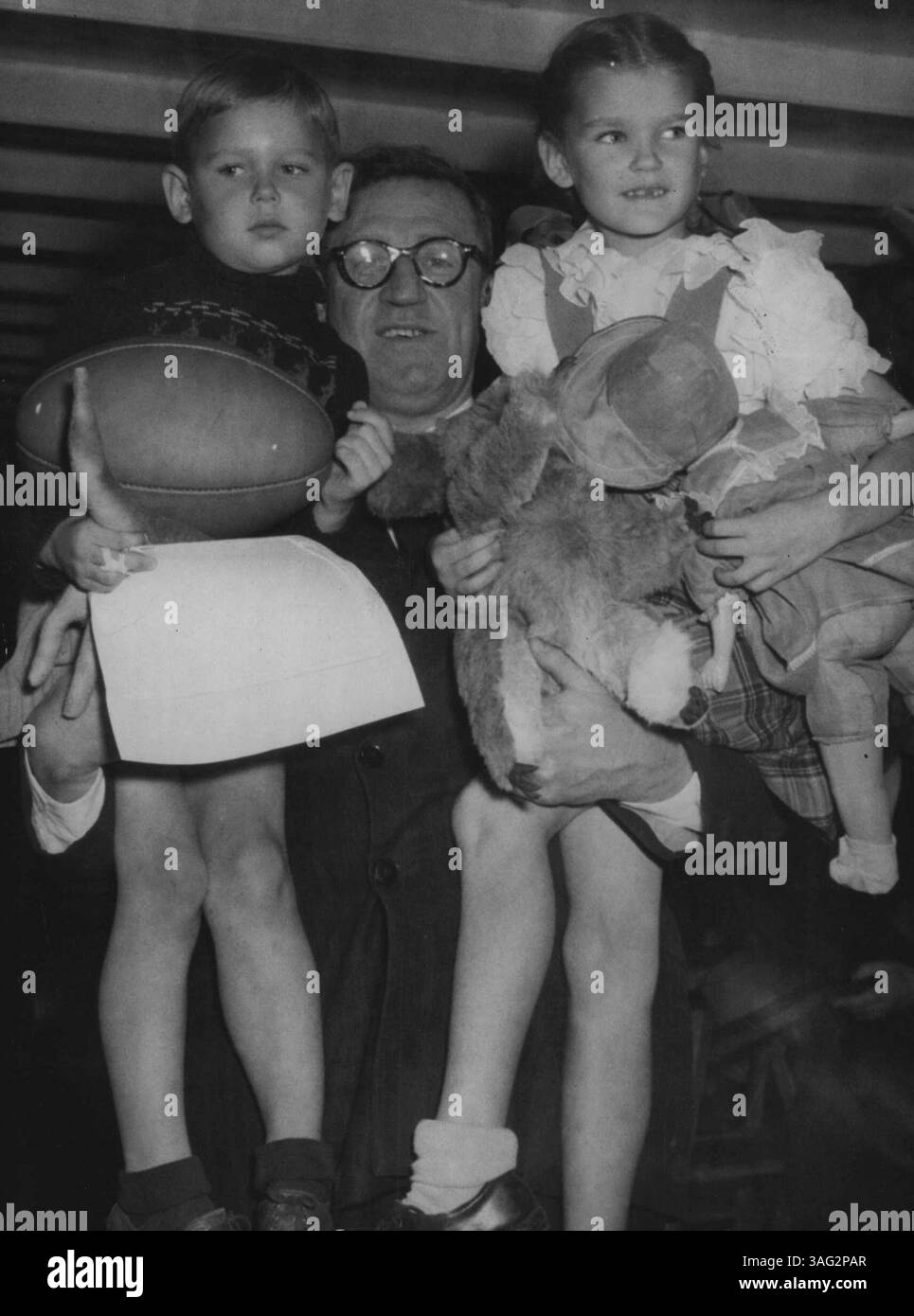 50, 000° DP dell'Australia. Migrante Maira Kalnins ***** gli inars del fratello di un anno sono raffigurati tra le braccia ***** Ministro dell'immigrazione Arthur A.Calwell. ***** Il segretario della Lega W.R. Orr ha dato agli inars un calcio e un ***** Regole del football australiano. 1° agosto 1949. Foto Stock