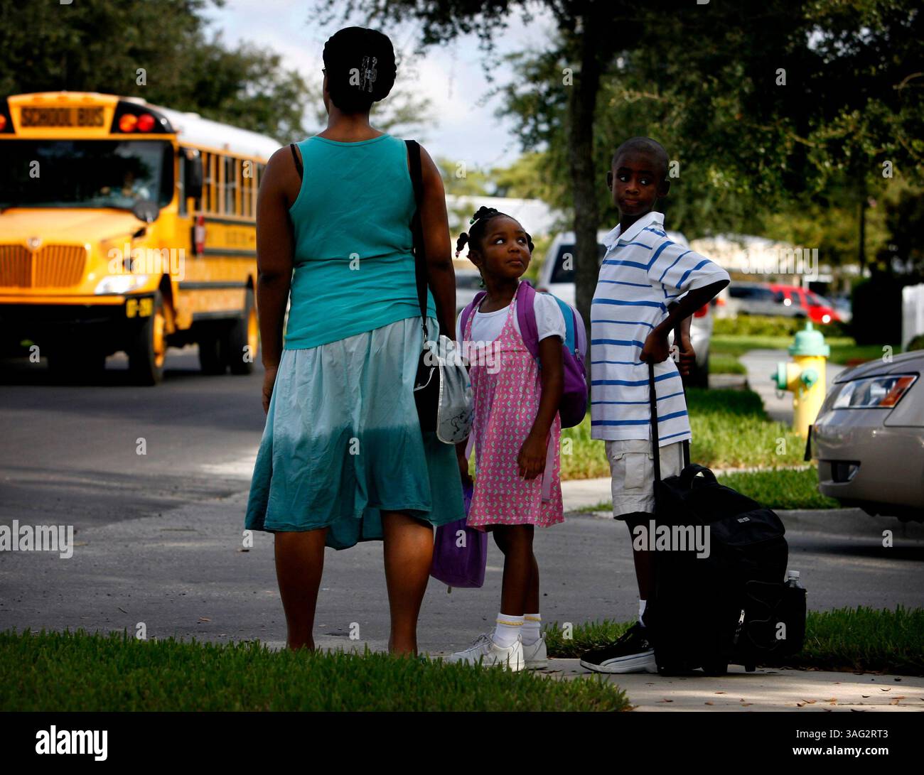 Trinity 9/4/08) 1. Shanta Tolbert, 30 anni, aspetta di attraversare la strada con i suoi figli Gabriella, 5 anni, e Isaia, 9 Tolbert, mentre vanno a scuola alla Longleaf Elementary il giovedì mattina. La famiglia guida per circa 13 chilometri prima di parcheggiare a un chilometro e mezzo dalla scuola, in modo che possano camminare. "Lo faccio per l'excerise." Dice Shanta. I bambini dicono che amano parlare mentre camminano fino a scuola (Credit Image: St Petersburg Times/ZUMAPRESS.com) Foto Stock
