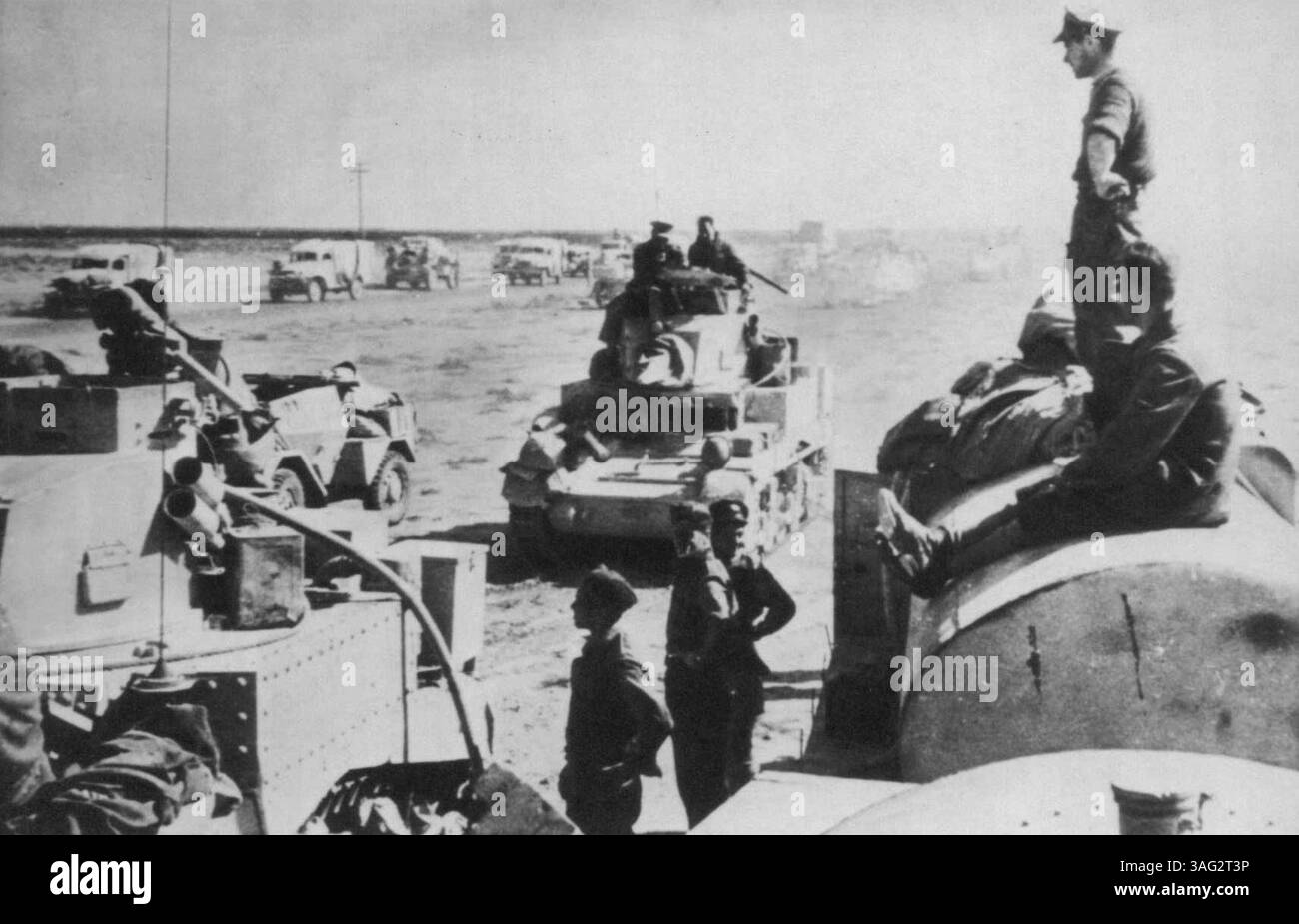 Rifornimento in prima linea - mentre le ambulanze della croce rossa e i camion di rifornimento sono in attesa, i carri armati britannici assumono un carico pieno da un camion a benzina sulla destra, a soli 800 metri di distanza dall'abbaiare i cannoni tedeschi. Durante la battaglia per Sidi Barrani in Egitto. Durante le operazioni di rifornimento gli aerei da caccia tedeschi attaccarono i veicoli ma furono dispersi da aerei R.A.F. 2 dicembre 1942. (Foto di AP Wirephoto). Foto Stock