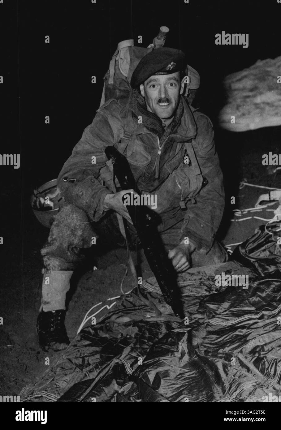 I Red Devils entrano nell'operazione Holdfast -- caporale Andrew Ferguson, di Glasgow, fotografato dopo l'atterraggio in Germania. Ha appena finito il paracadute ed è pronto per l'azione. Tre compagnie di paracadutisti del fine settimana il 46° battaglione paracadutisti della 16° Divisione dell'Esercito territoriale - sono scese dalla pioggia da nove aerei boxcar durante l'operazione Holdfast in Germania ieri. Hanno fatto una delle cadute di paracadute più perfette di sempre, proprio sul bersaglio. Il loro lavoro era quello di distruggere munizioni e depositi di benzina dell'esercito "Blu" in ritirata. Gli sbarchi furono effettuati a UNNA, sul Dortmund roa Foto Stock