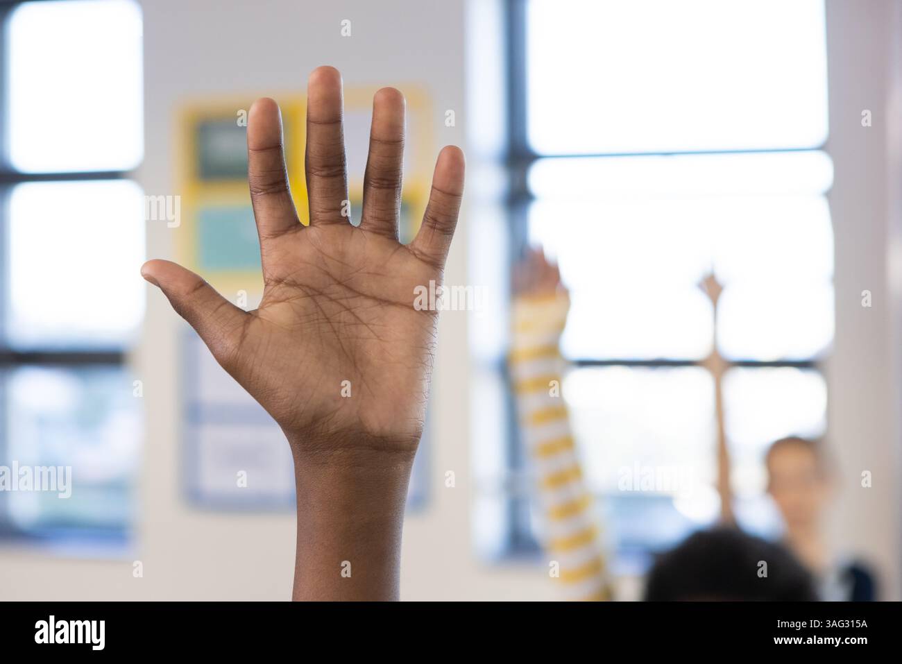 Alzando la mano in classe, ragazzo afroamericano che partecipa attivamente alla lezione scolastica Foto Stock